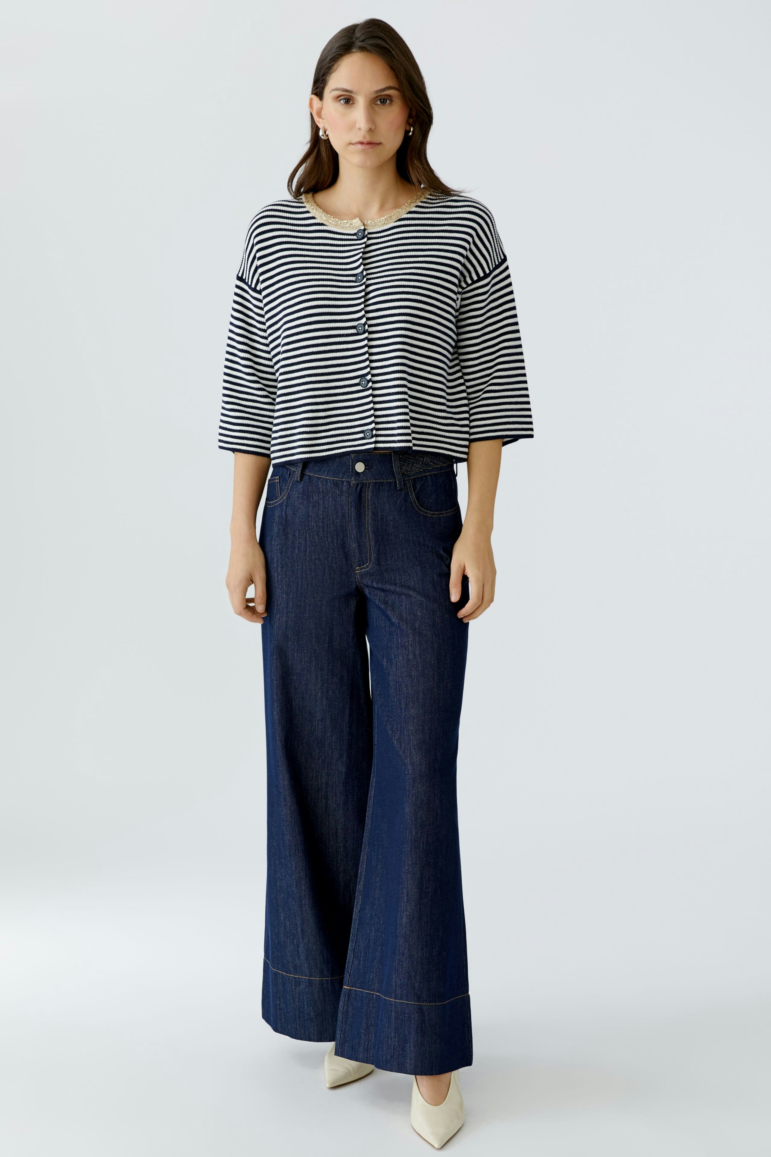 Casual women's cardigan: A woman in a striped cardigan paired with wide-leg jeans stands confidently.