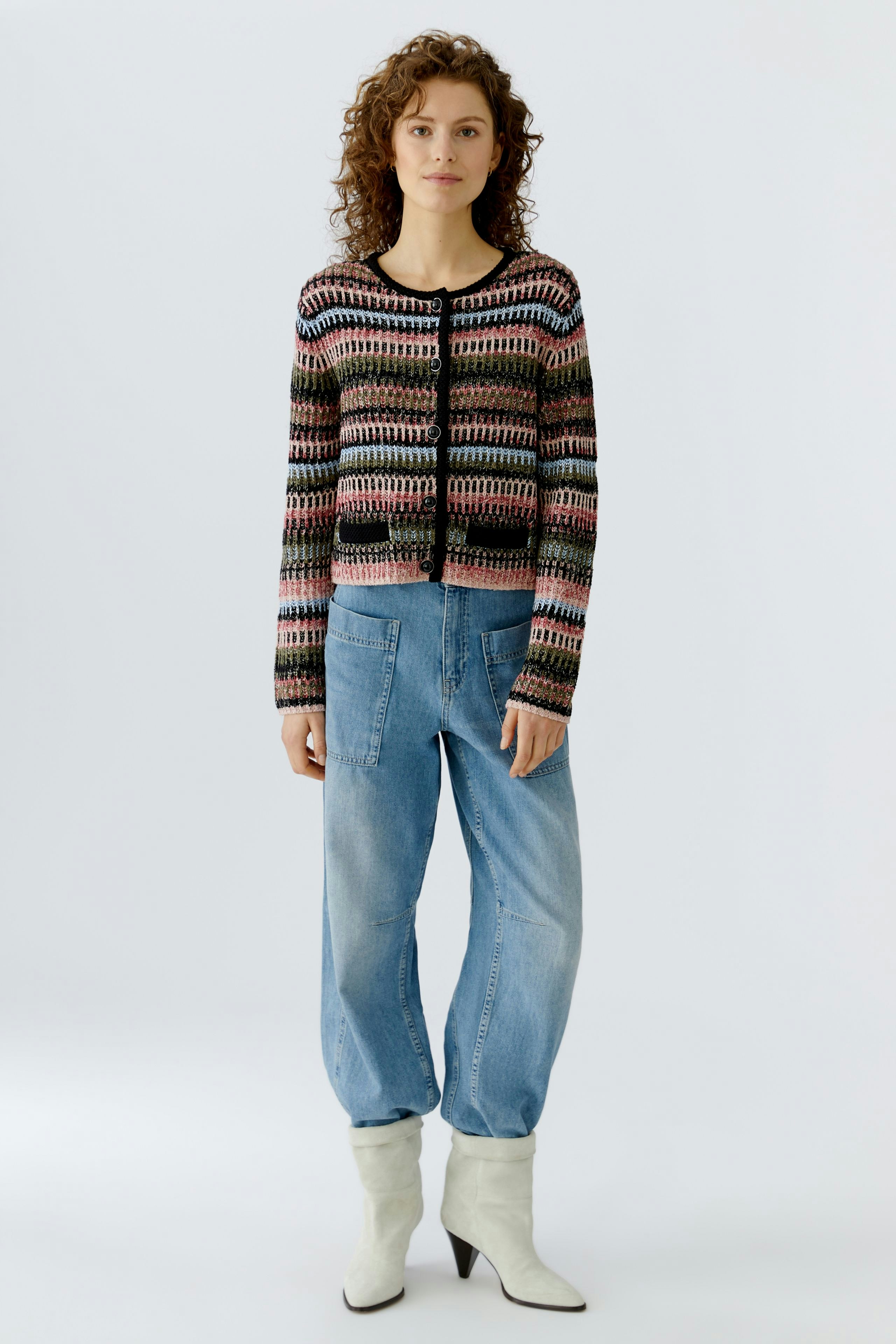 Casual women's cardigan: A woman in a colorful knitted cardigan paired with relaxed jeans.