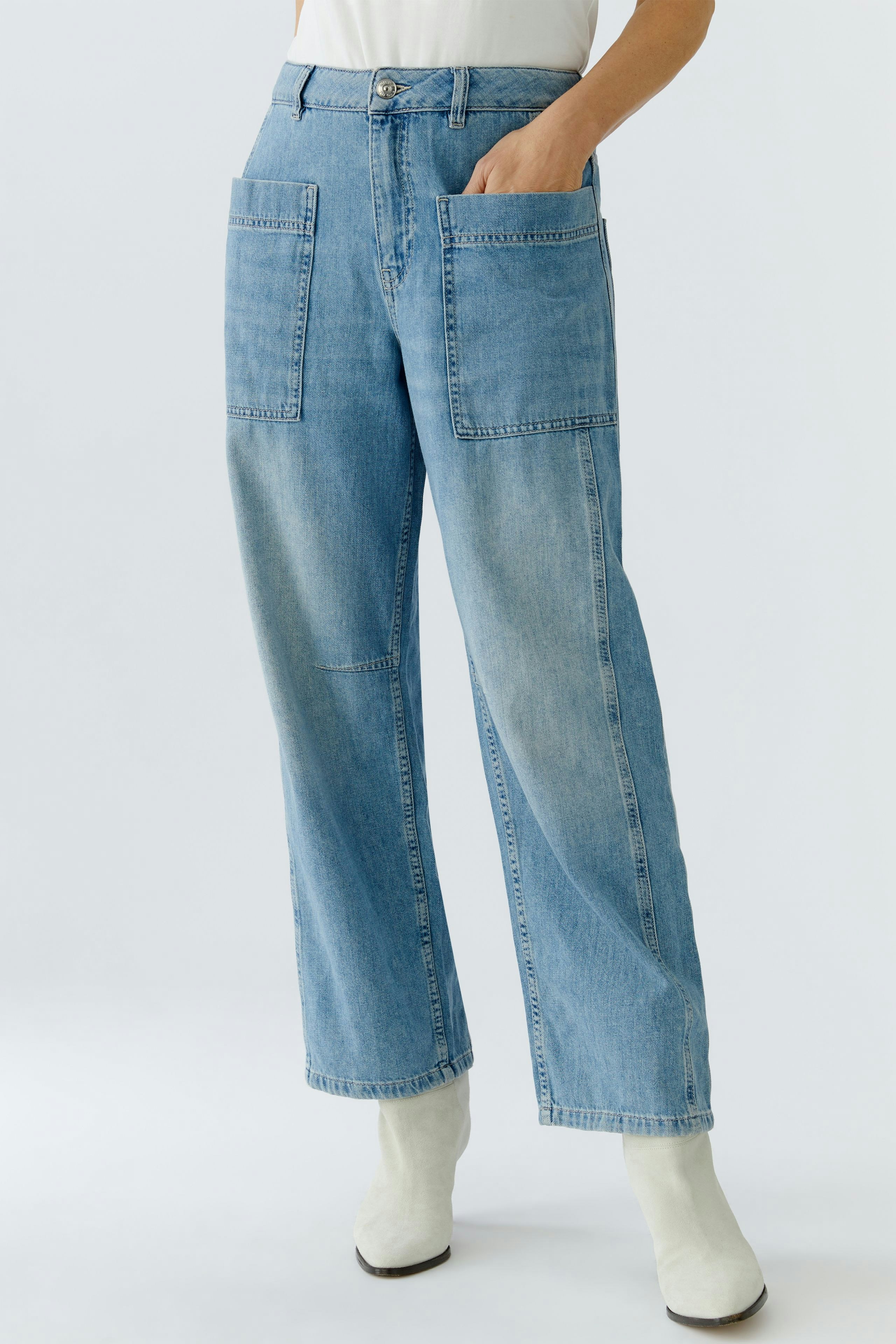 Casual women's jeans: A woman in light blue barrel jeans with large pockets, styled with a simple top.