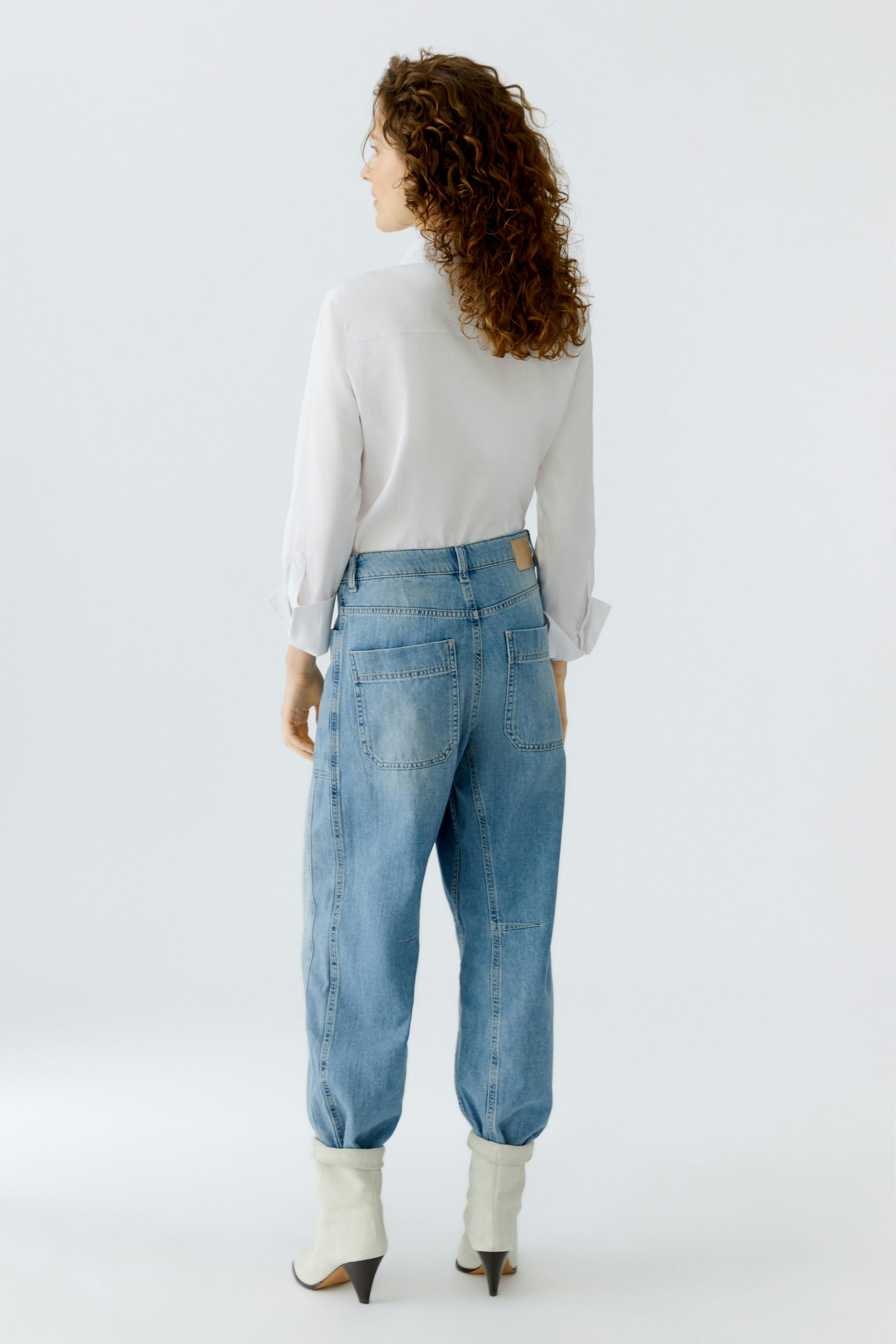 Casual women's jeans: A woman in light blue barrel jeans with a relaxed fit, showcasing a stylish look.