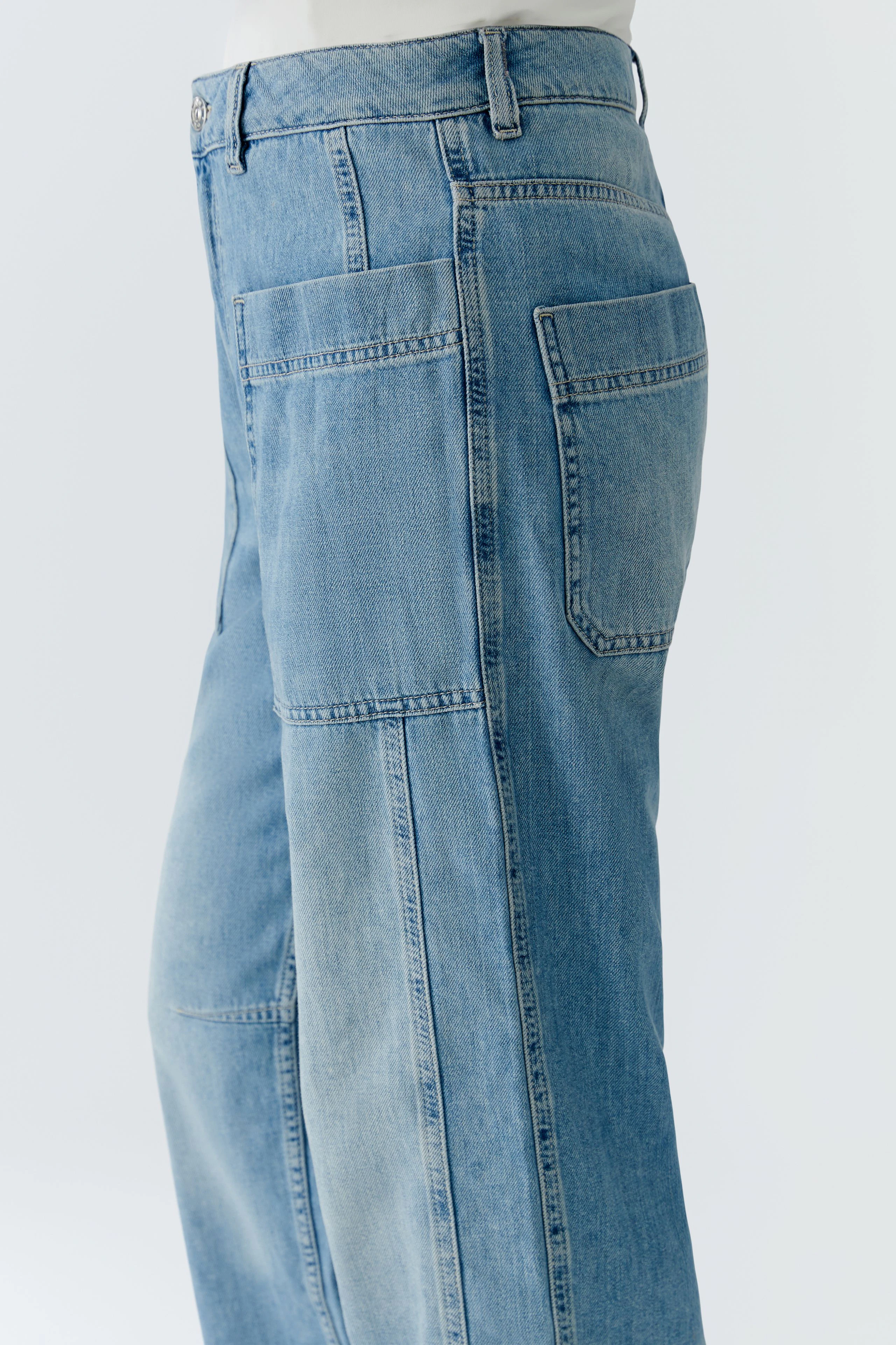 Bequeme Jeans Barrel: Frau trägt lässige, hellblaue Jeans mit praktischen Taschen und weitem Schnitt.