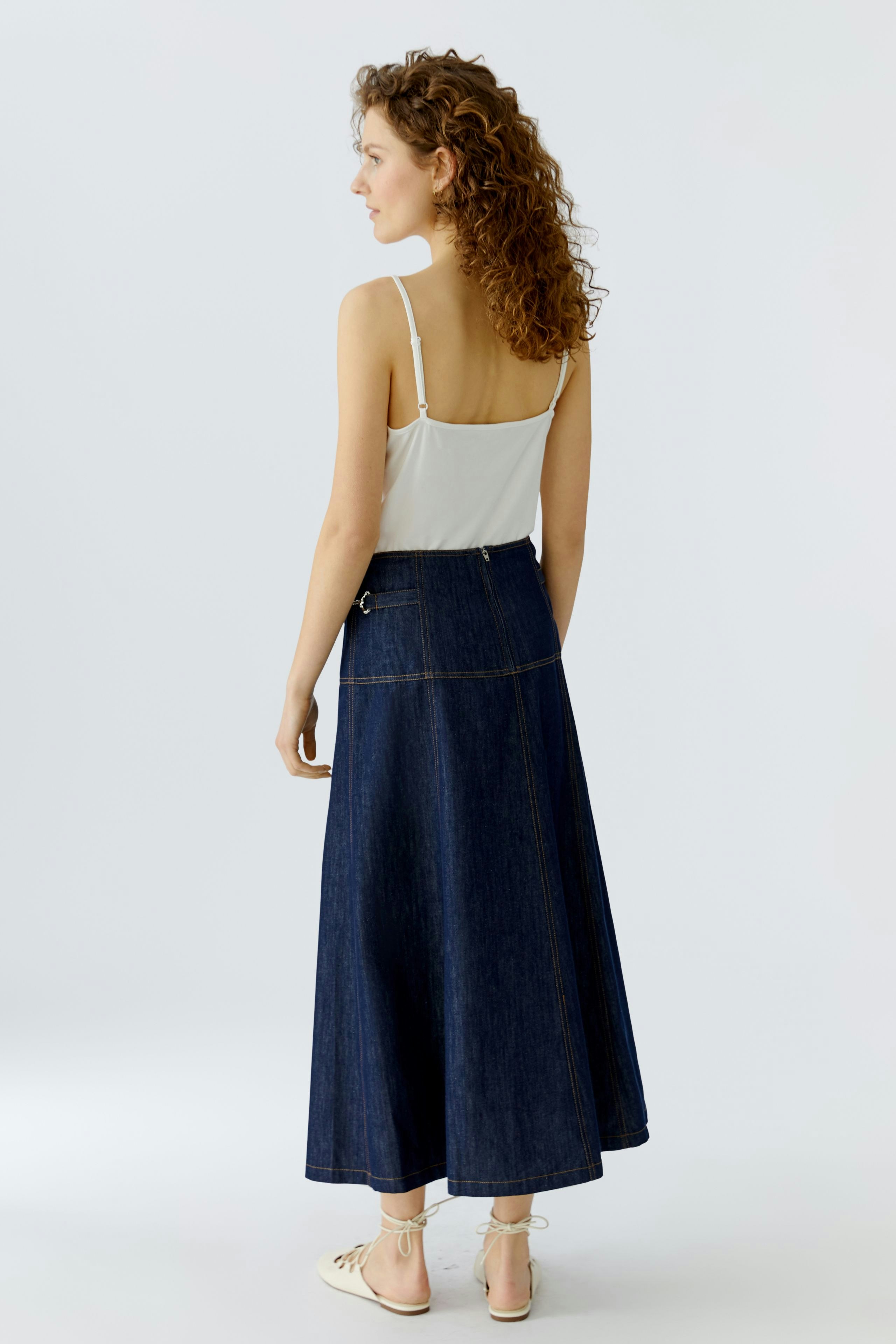 A-line skirt: Woman in a long denim skirt with a simple top, showcasing a casual style.