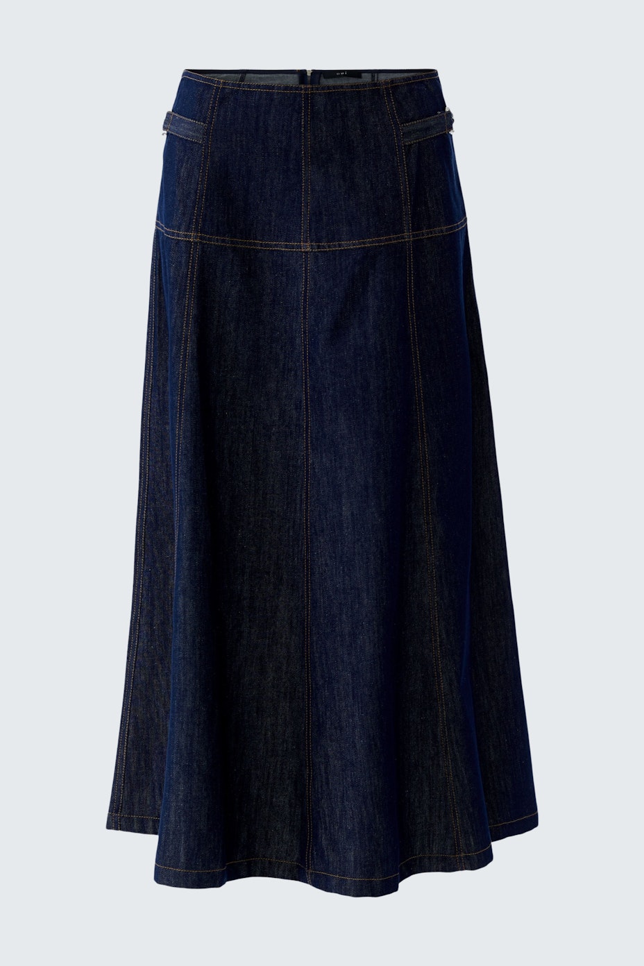 Denim A-line skirt: A woman in a dark blue A-line skirt with visible stitching, showcasing a casual style.