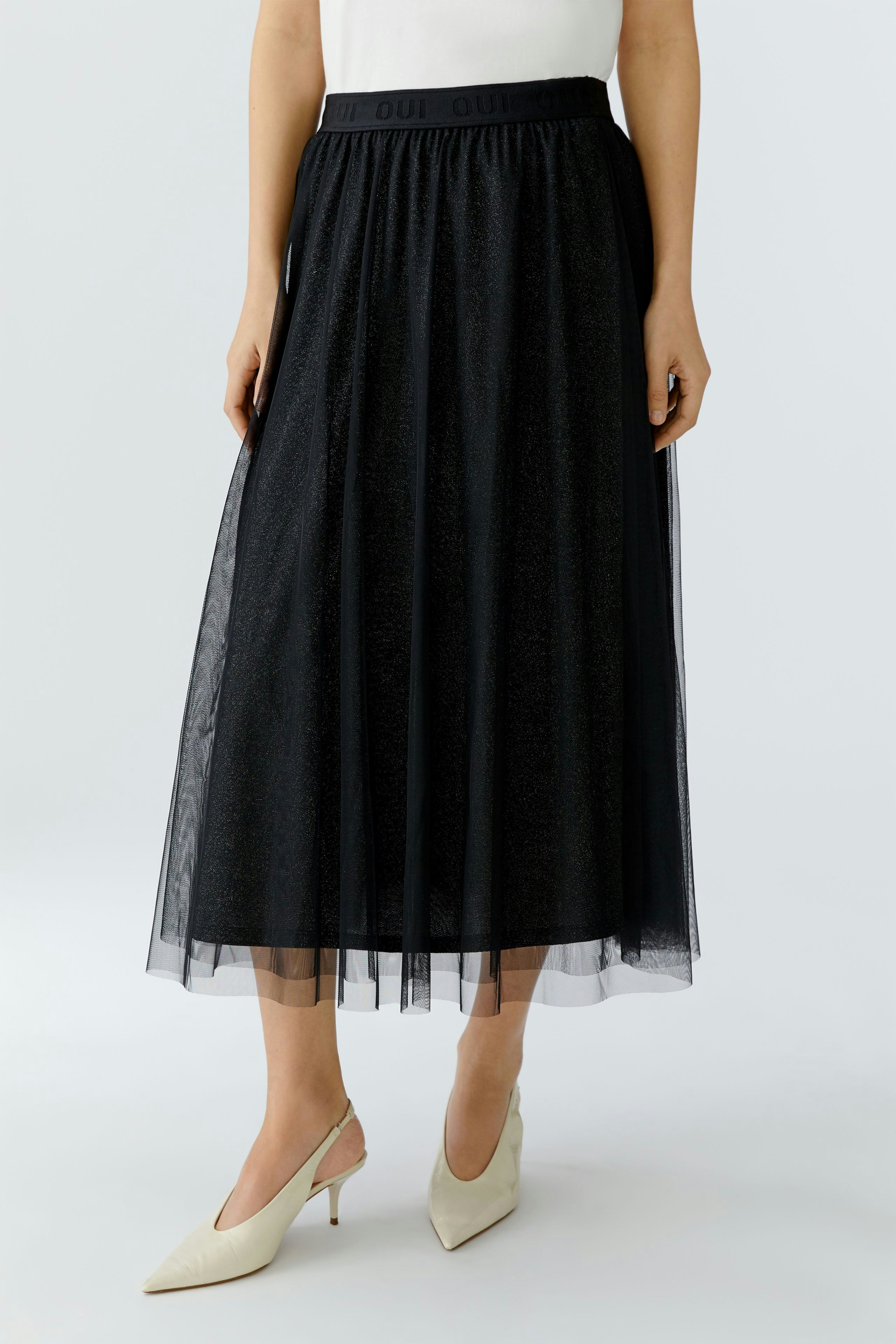 A-line skirt: Woman in a black tulle skirt with a comfortable waistband, paired with stylish heels.