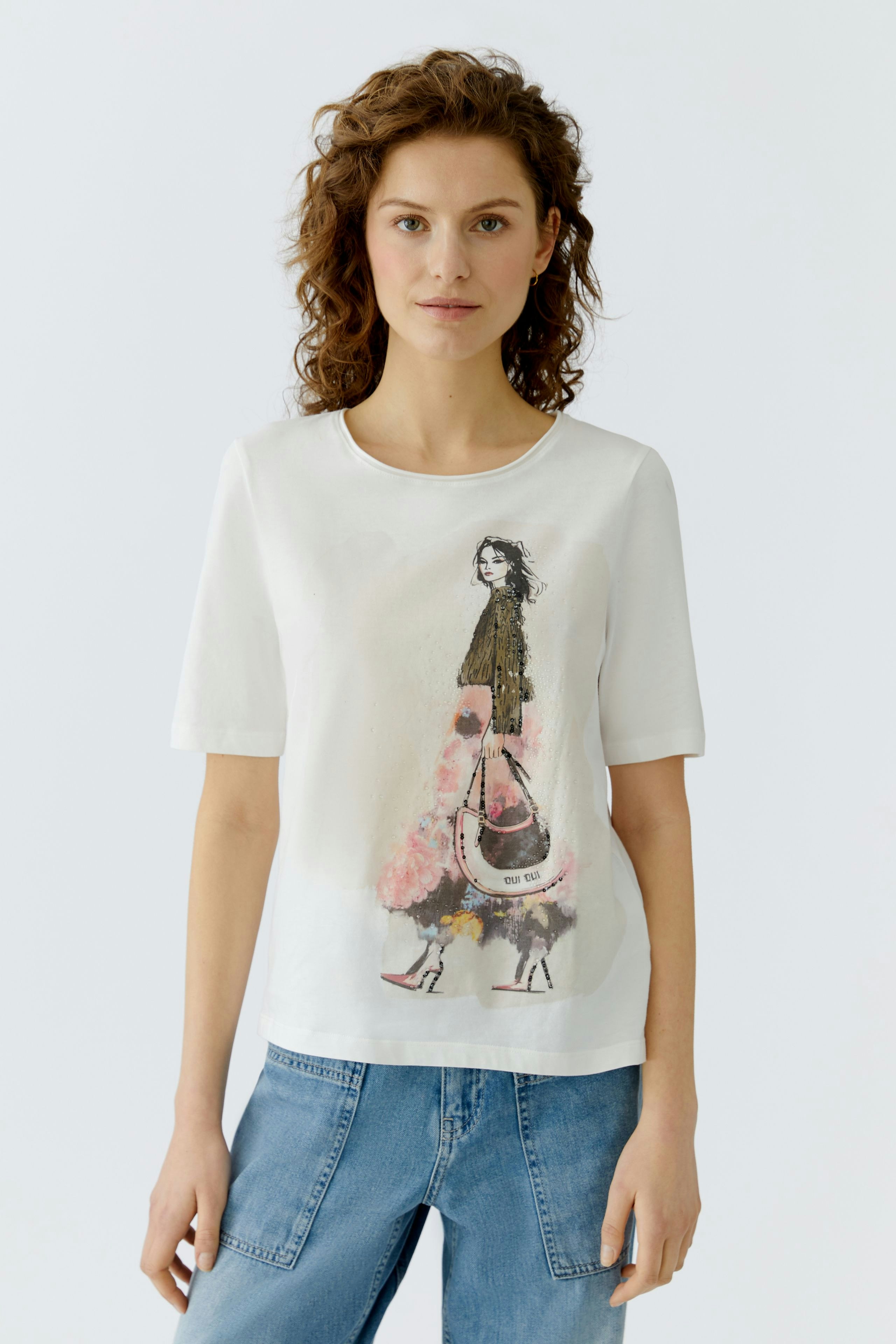 Casual women's T-shirt: Woman in a white tee with a colorful fashion illustration, paired with denim.