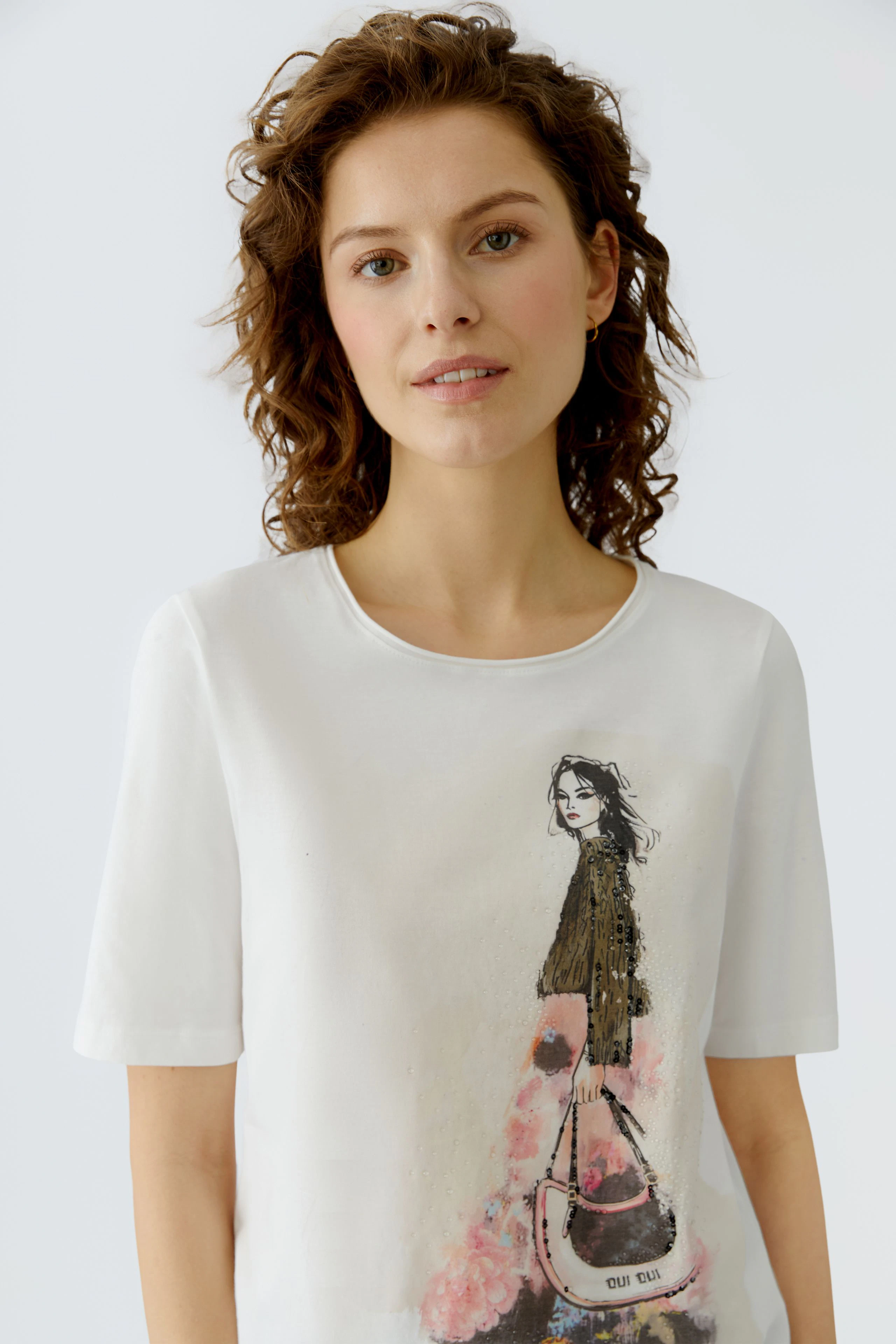 Casual women's T-shirt: Young woman in a white tee featuring a stylish graphic design.