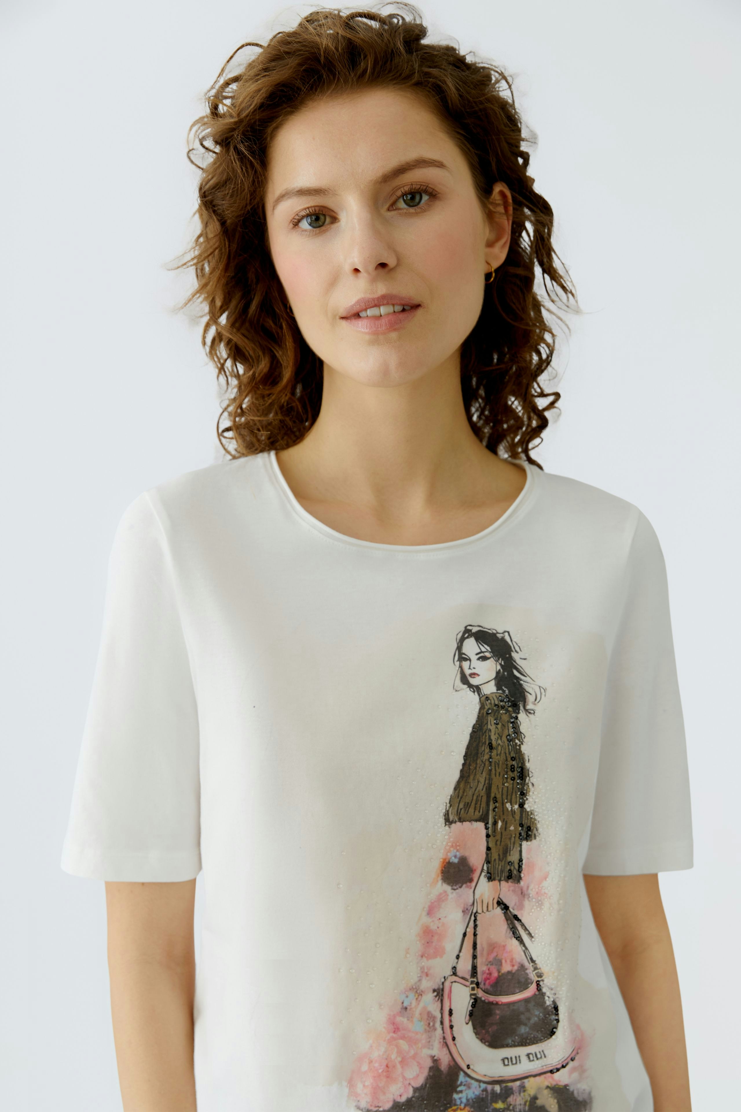 Casual women's T-shirt: Young woman in a white tee featuring a stylish graphic design.