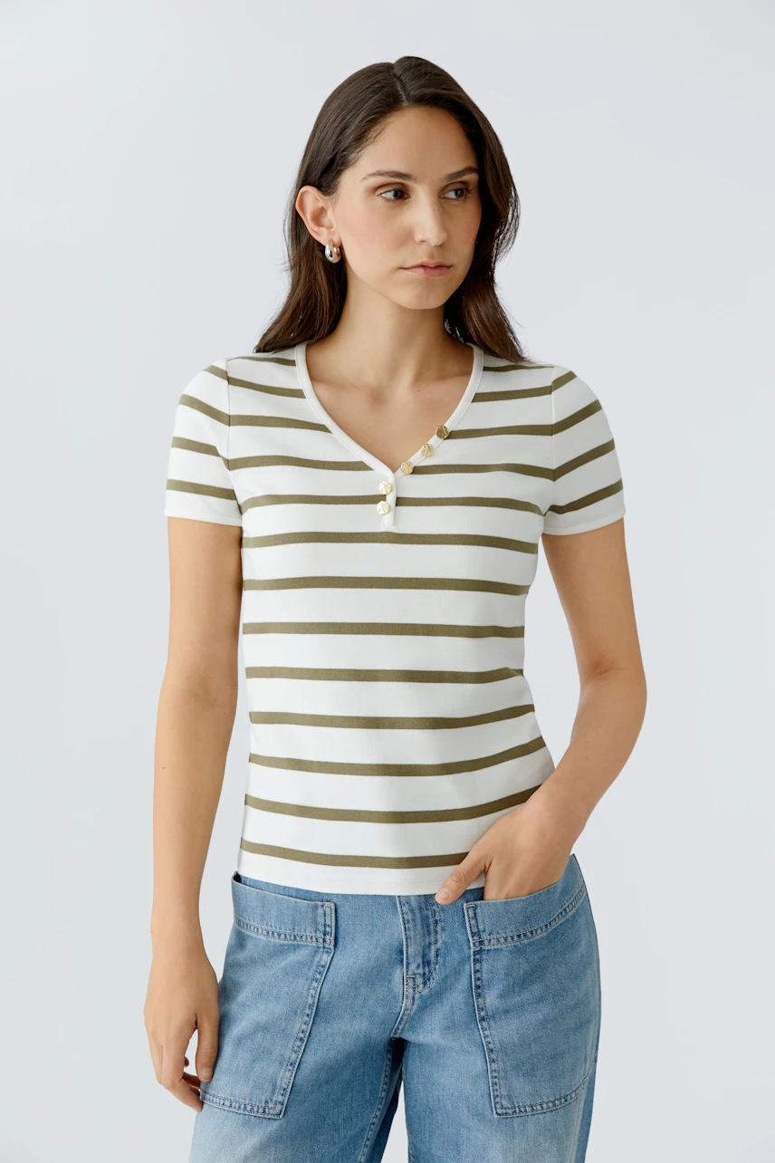 Damen-T-Shirt: Junge Frau trägt ein gestreiftes T-Shirt mit Knöpfen und lässigen Jeans.