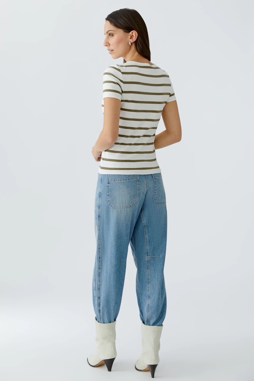 Damen-T-Shirt: Frau trägt ein gestreiftes T-Shirt in Beige und Weiß, kombiniert mit lässigen Jeans.