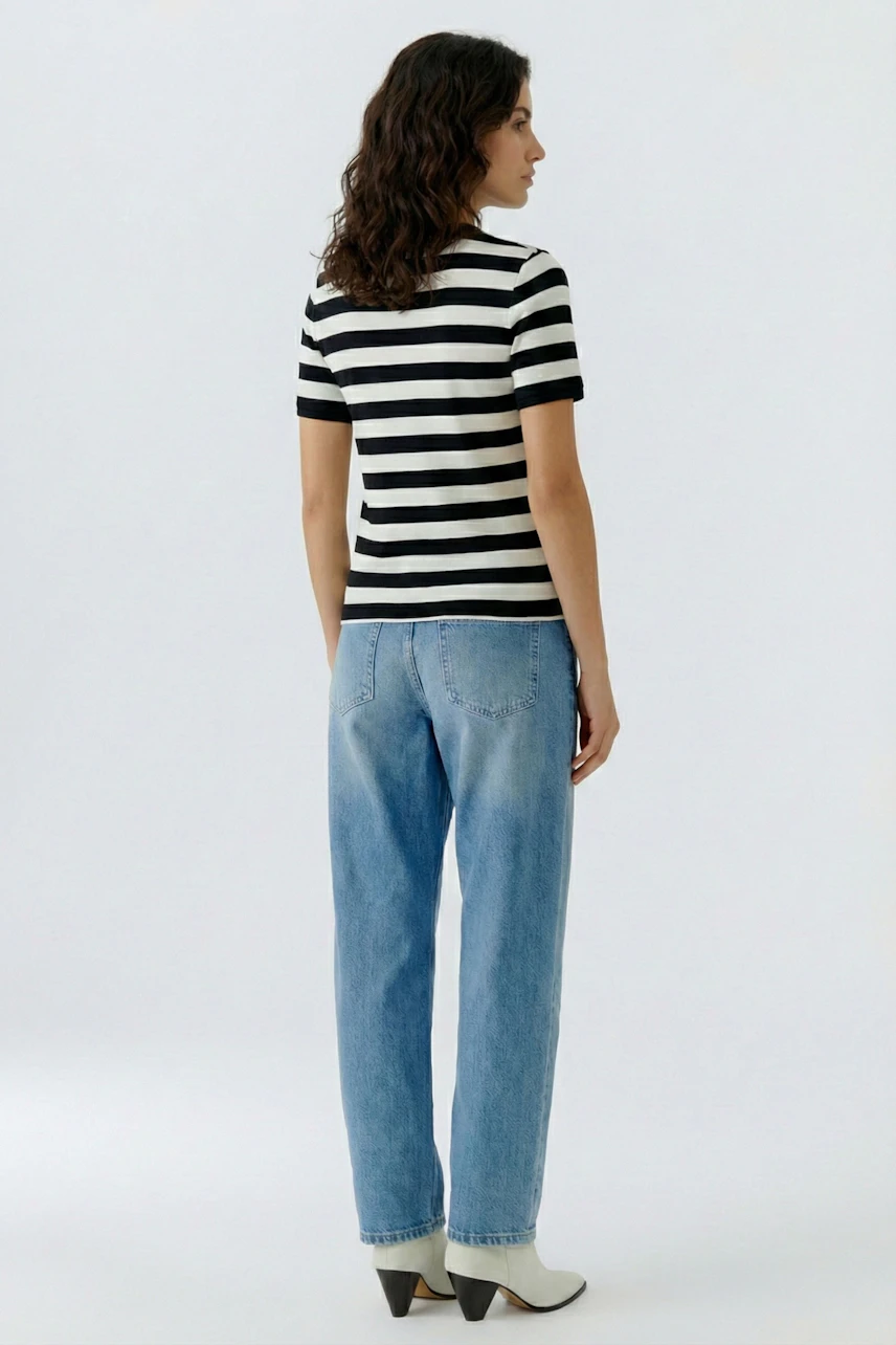 Casual women's T-shirt: Young woman in a black and white striped tee paired with relaxed jeans.
