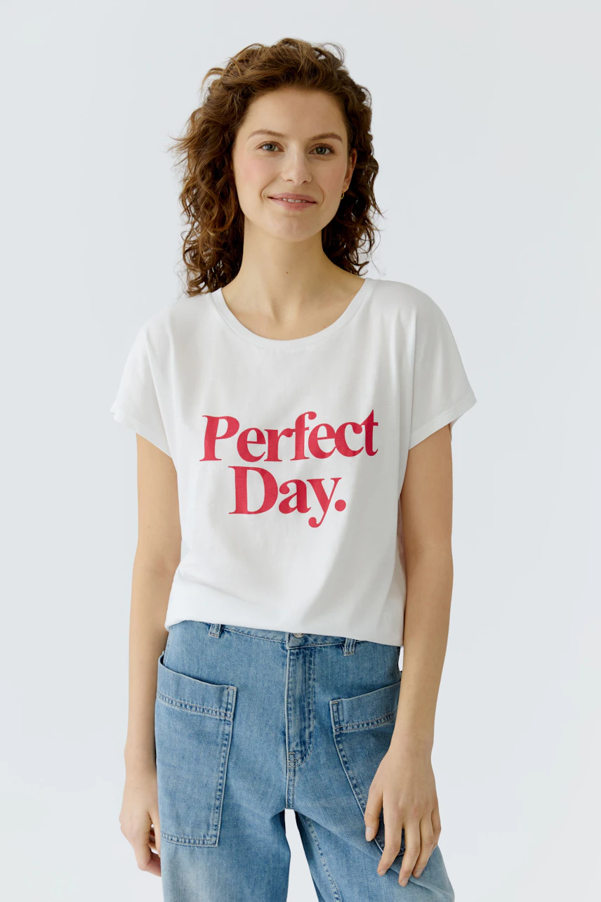 Casual women's T-shirt: Young woman in a white tee with 'Perfect Day.' print and relaxed fit.