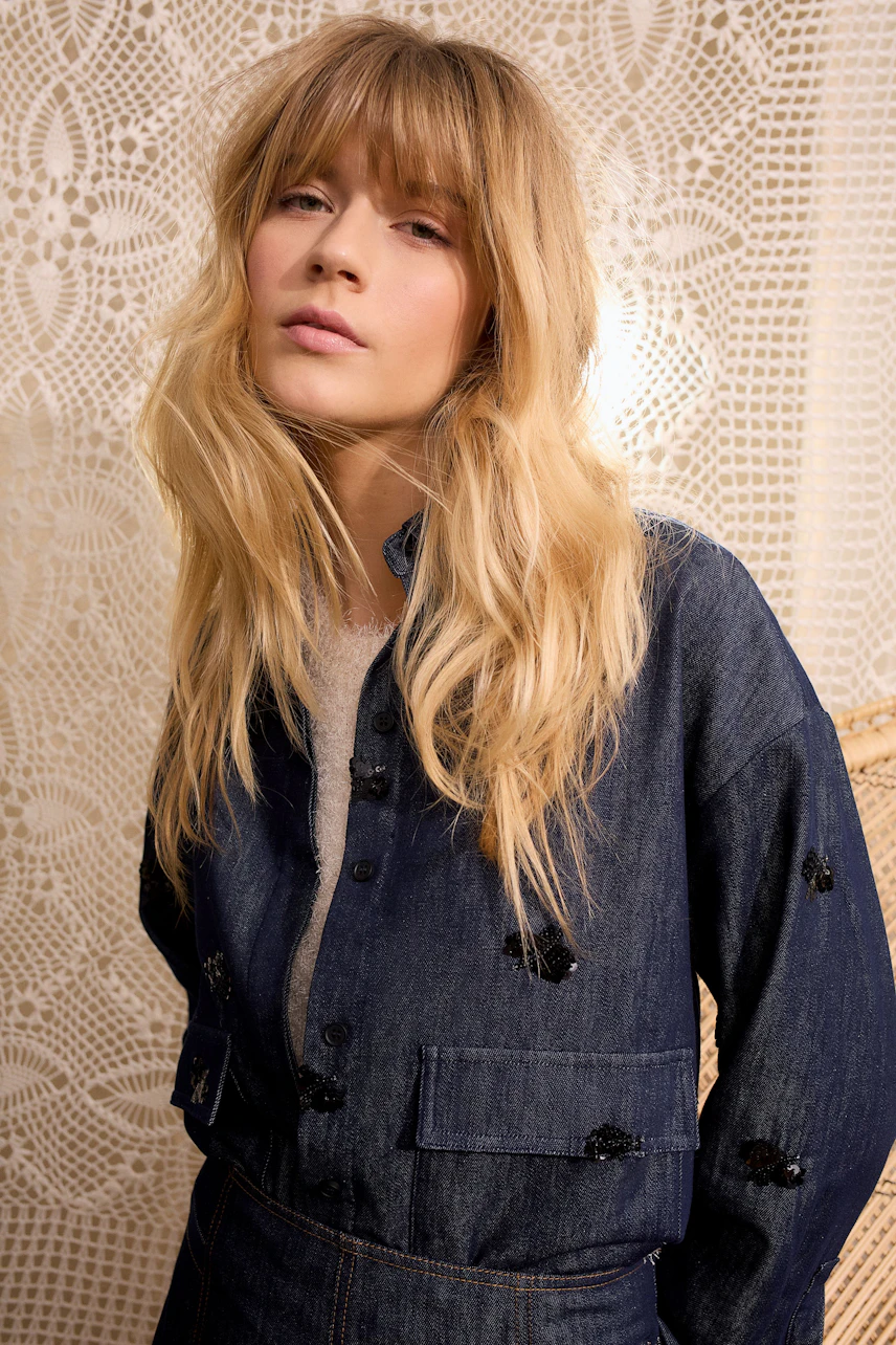 Damen-Jacke: Frau in blauer Jeansjacke mit feinen Details, lässig und modern.