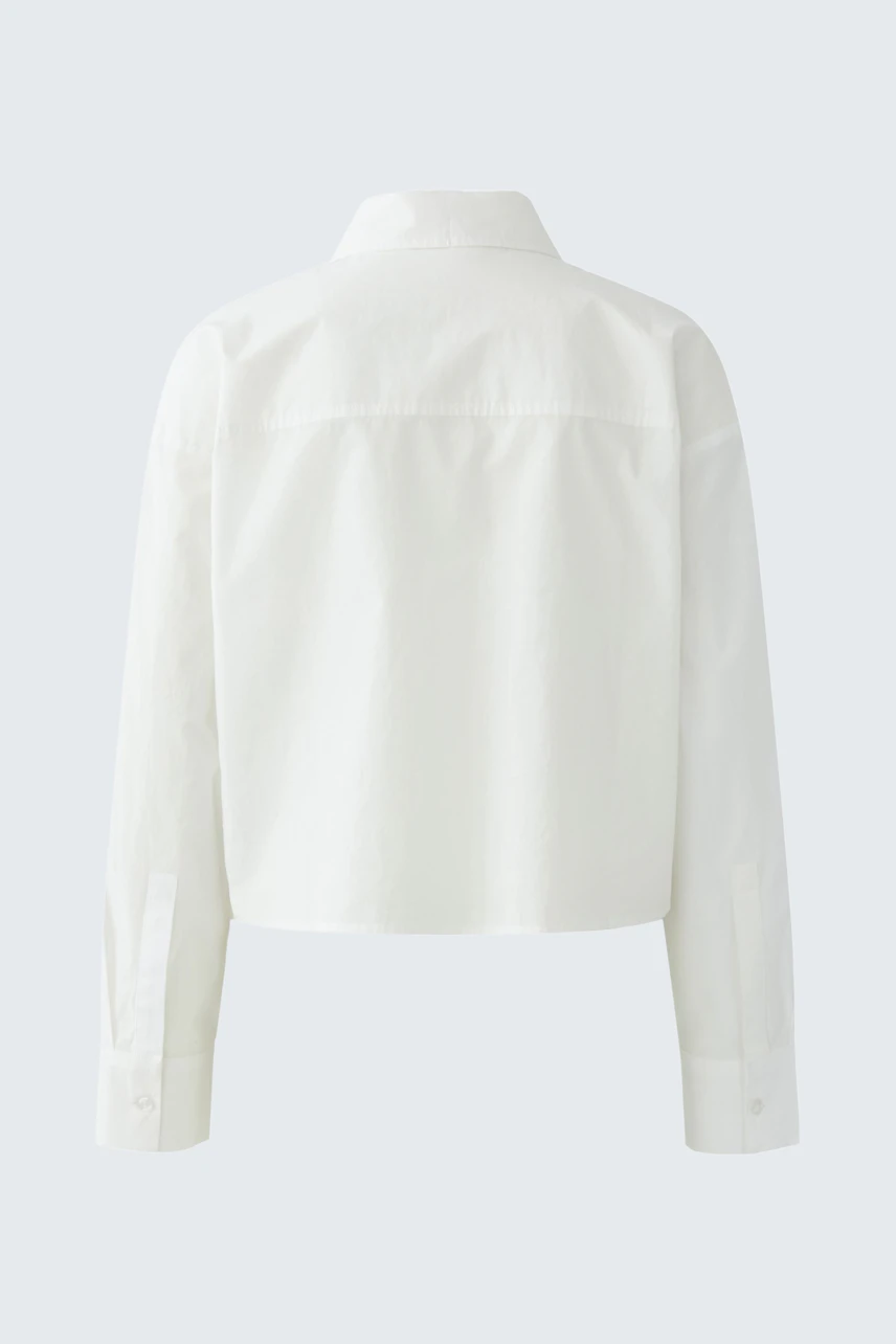 Casual women's blouse: A woman in a cropped white blouse with a classic collar and long sleeves.