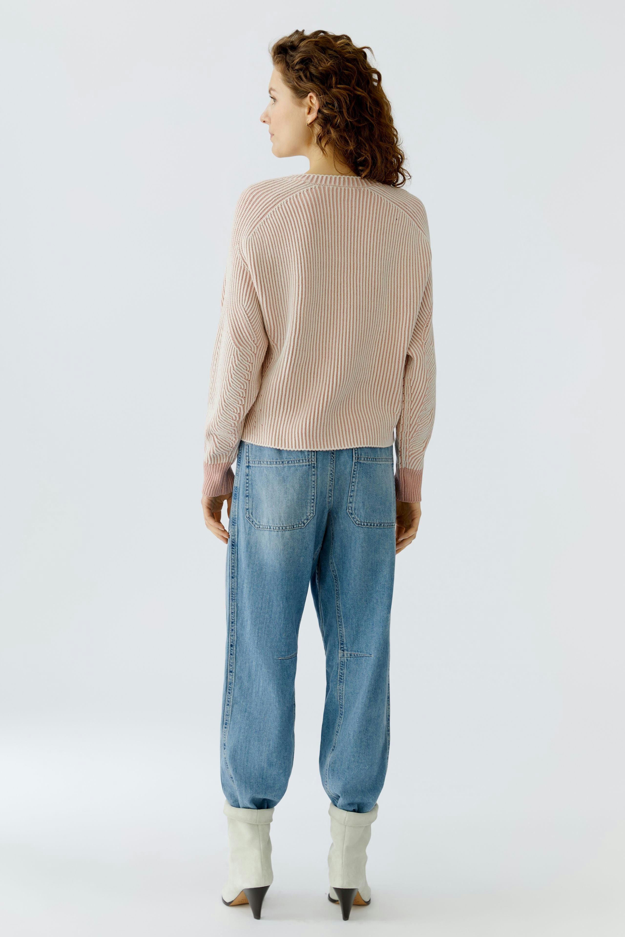 Casual women's pullover: A woman in a striped pullover and relaxed jeans, showcasing a laid-back style.
