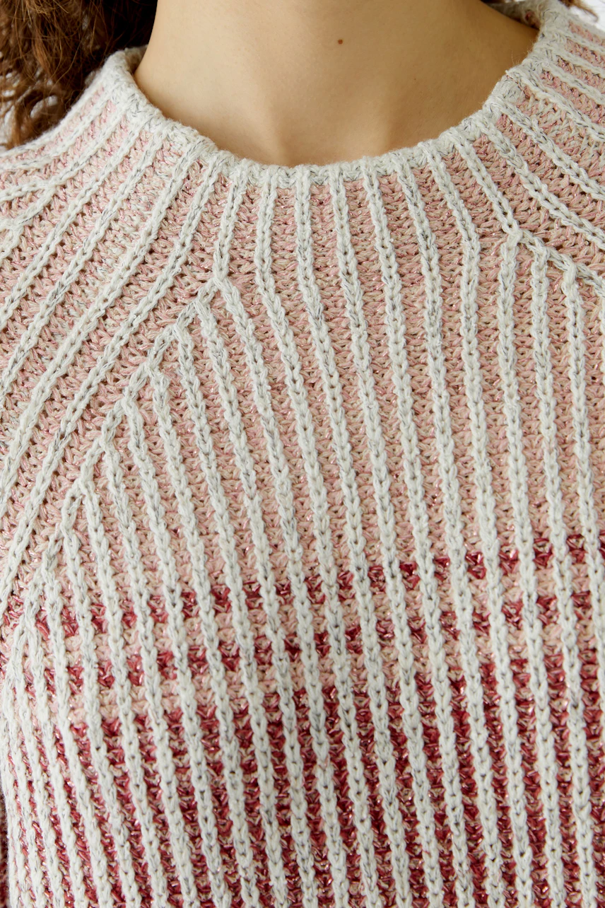 Damen-Pullover: Frau trägt einen gestreiften Pullover in sanften Farben mit Rundhalsausschnitt.