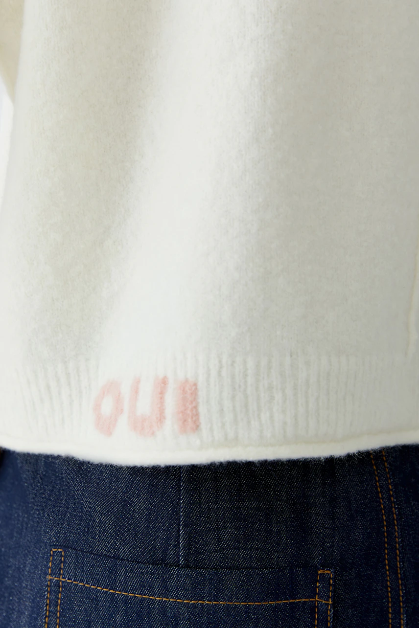 Cozy women's pullover in soft white with a subtle logo detail at the hem.