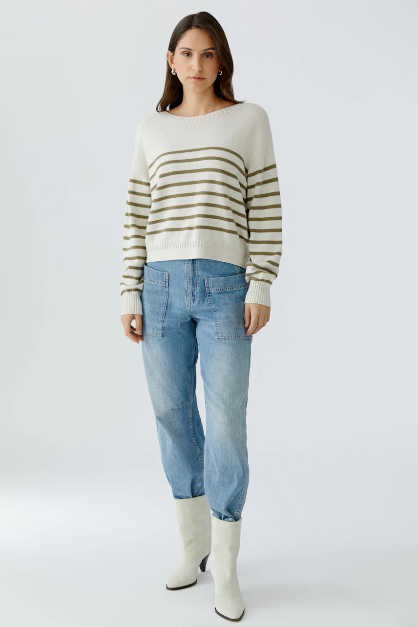 Casual women's pullover: A woman in a striped pullover paired with light blue jeans.