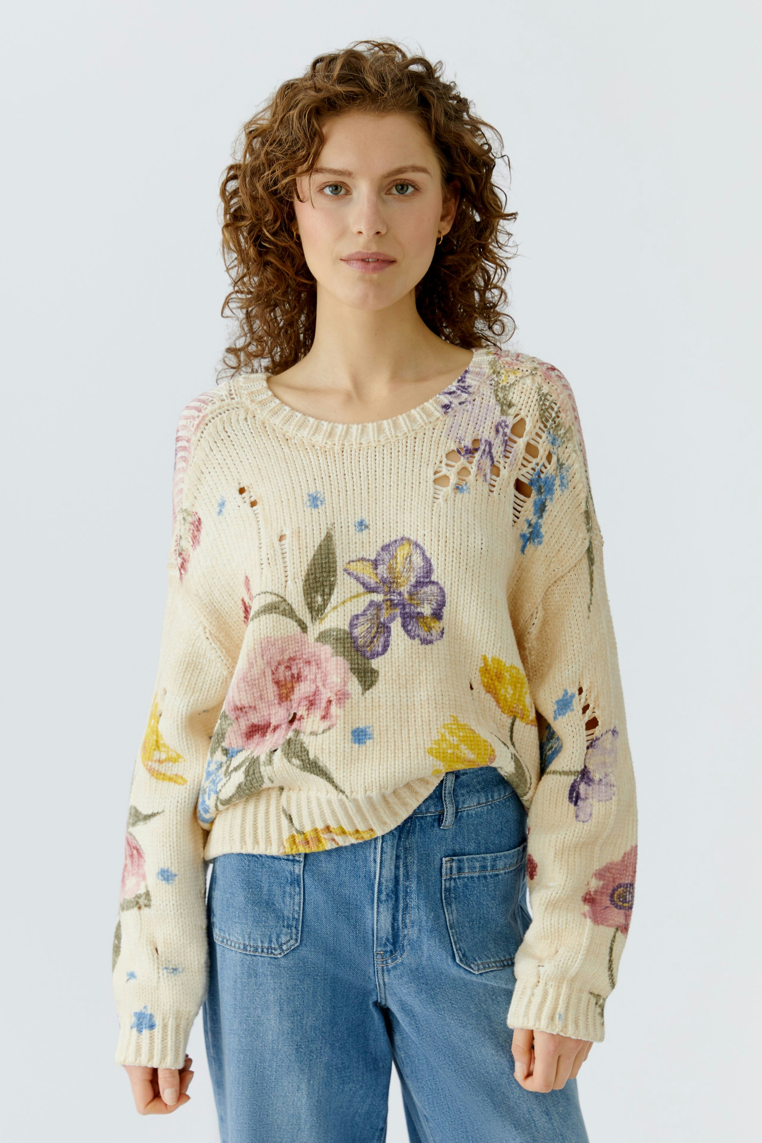 Casual women's pullover: A woman in a floral knit pullover paired with blue jeans, exuding a relaxed vibe.