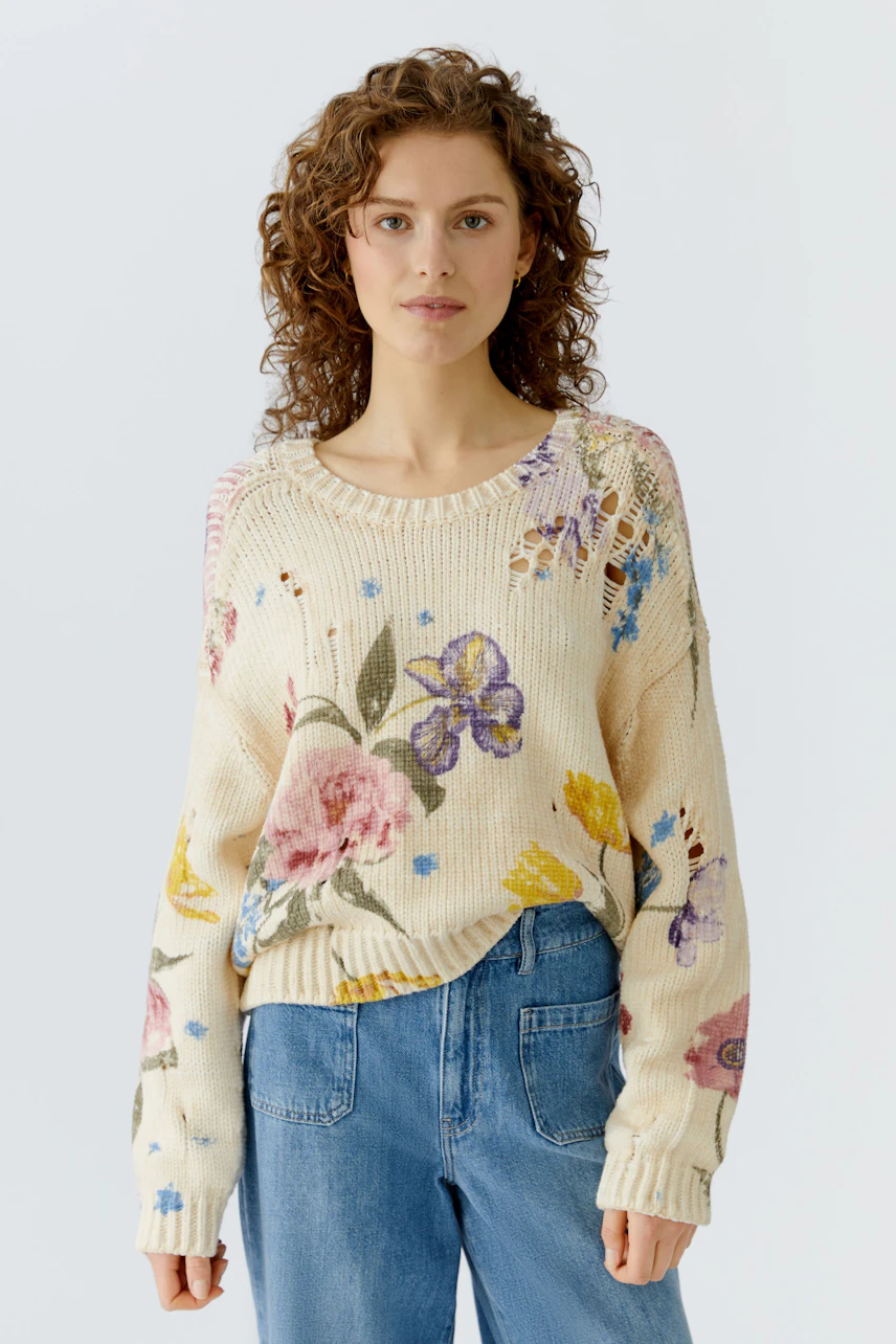 Casual women's pullover: A woman in a floral knit pullover paired with blue jeans, exuding a relaxed vibe.