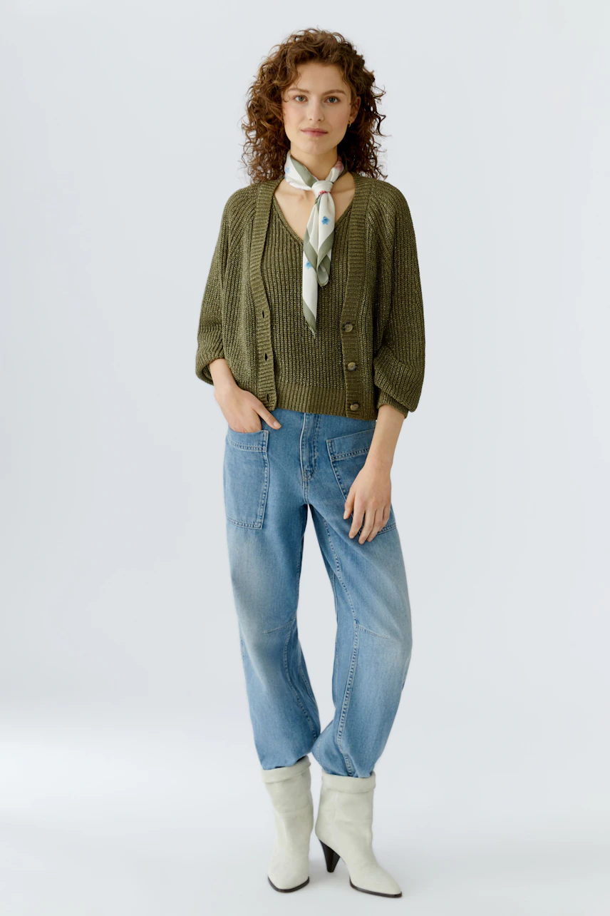 Damen-Tuch: Junge Frau mit grünem Strickpullover und Tuch in sanften Farben, lässig und modern.