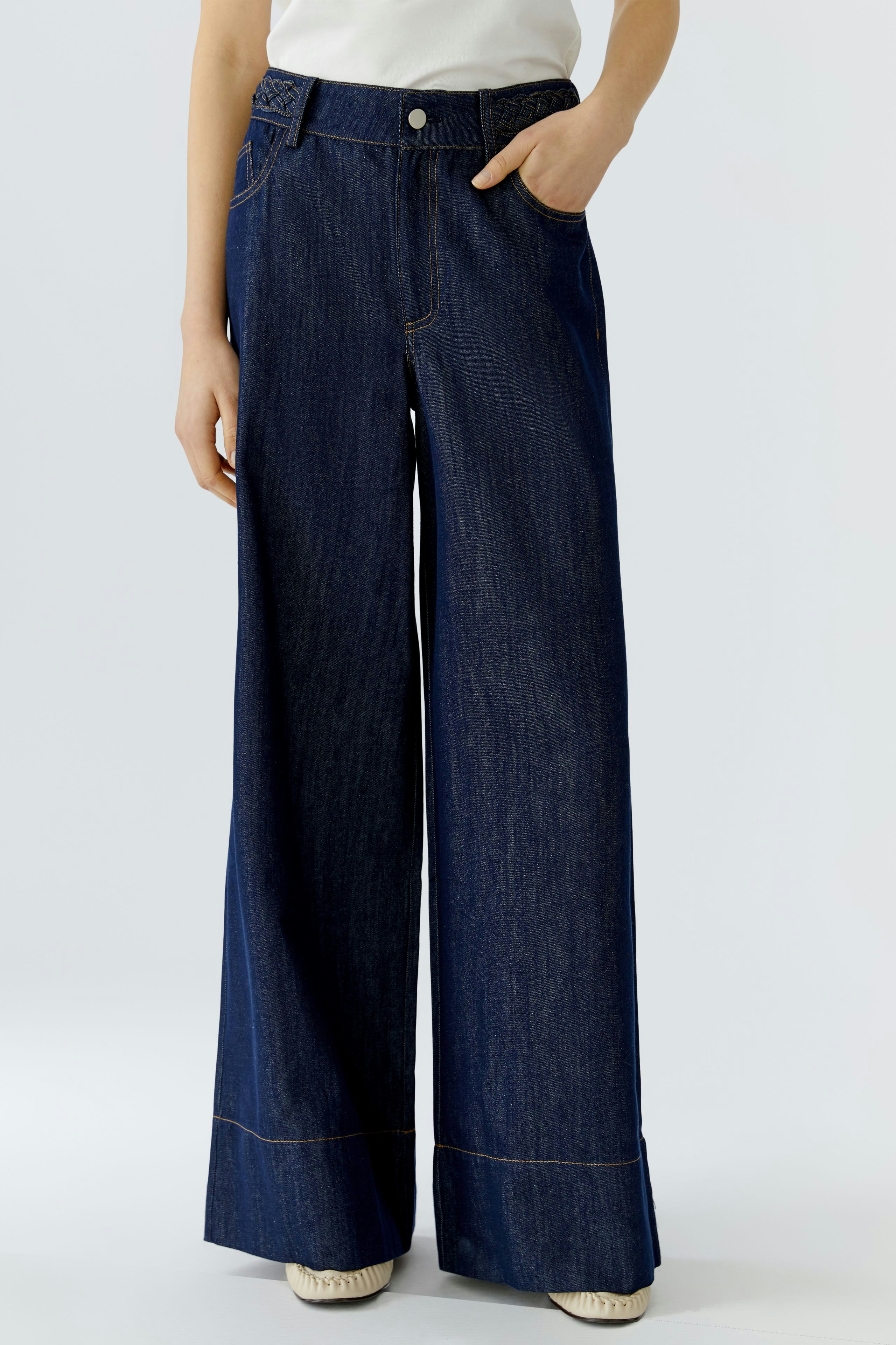 Wide leg jeans for women: A woman in dark blue wide leg jeans with a casual top.