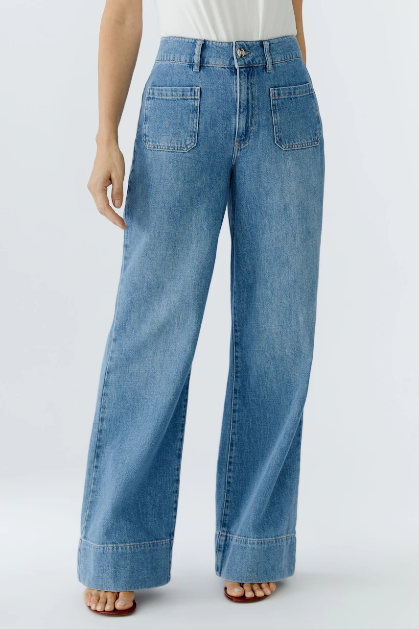 Bequeme Jeans Wide Leg: Frau trägt lässige, weite Jeans in hellem Denim mit hohen Taschen.