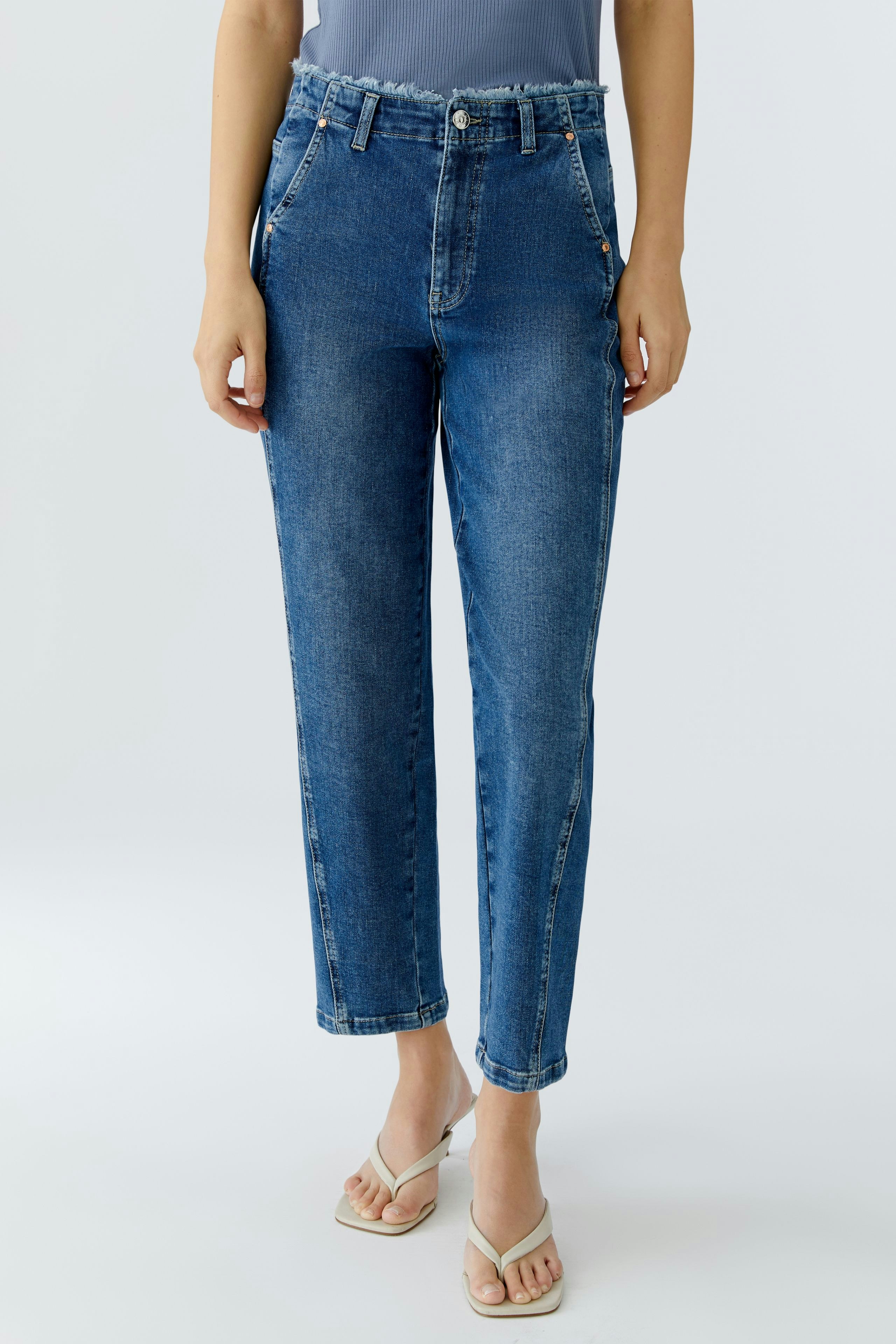 Casual women's tapered jeans: A woman in blue tapered jeans with a relaxed fit and stylish design.