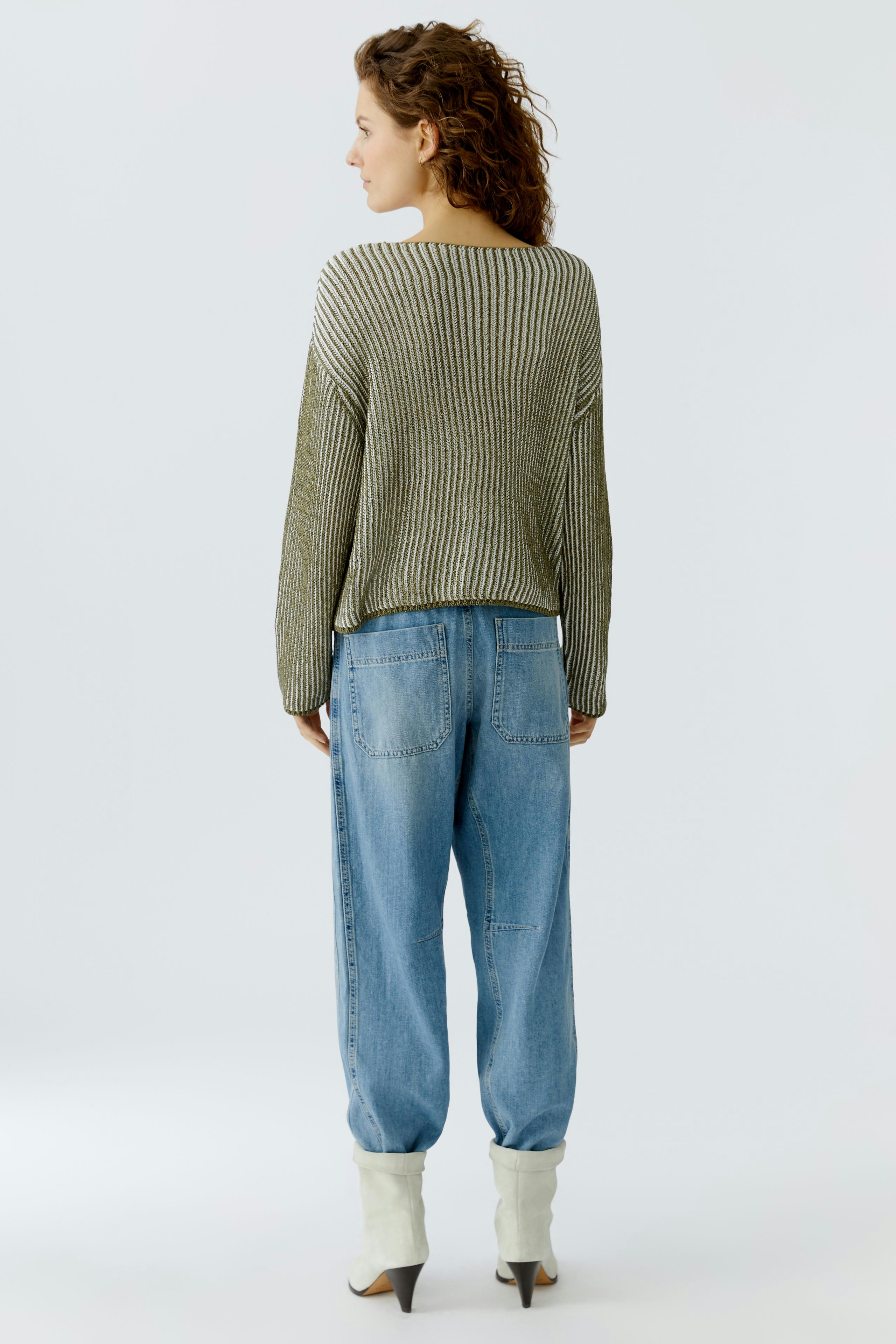 Casual women's pullover: A woman in a relaxed, striped pullover paired with loose jeans.