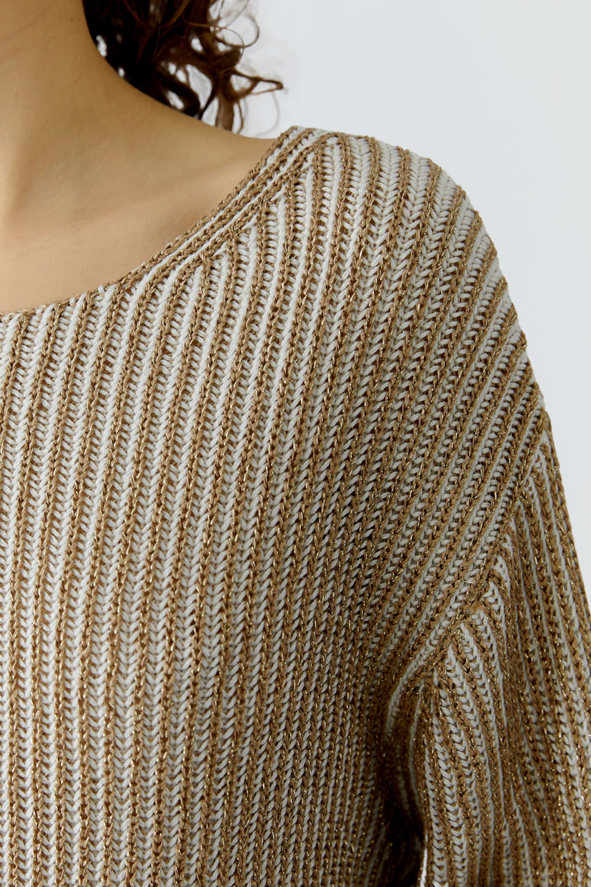 Damen-Pullover: Frau trägt einen beigen, gestreiften Pullover mit weitem Ausschnitt und lässigem Schnitt.