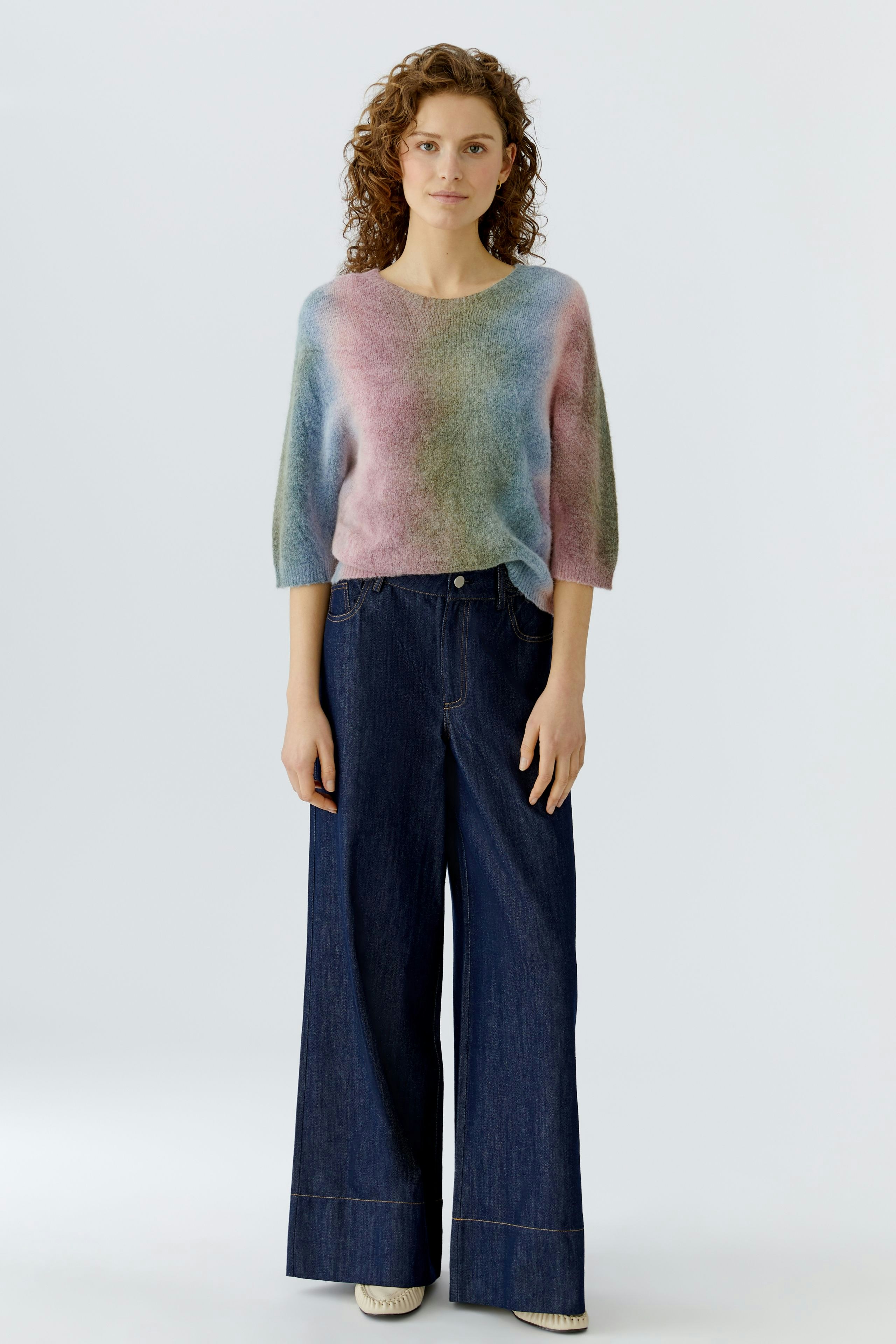 Casual women's pullover: A woman in a colorful, soft pullover paired with wide-leg jeans.