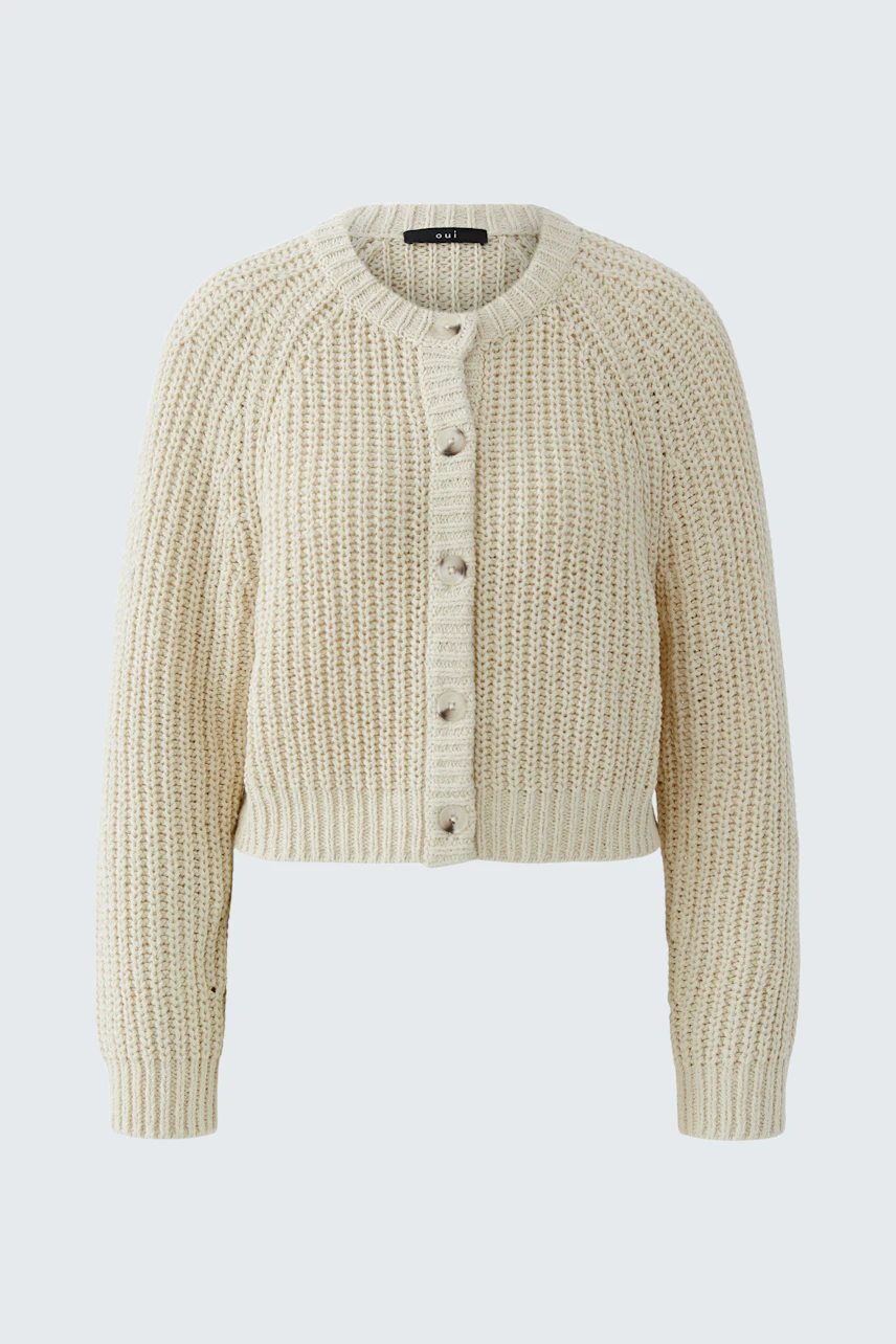 Casual women's cardigan: A woman in a cream knitted cardigan with buttons, perfect for layering.
