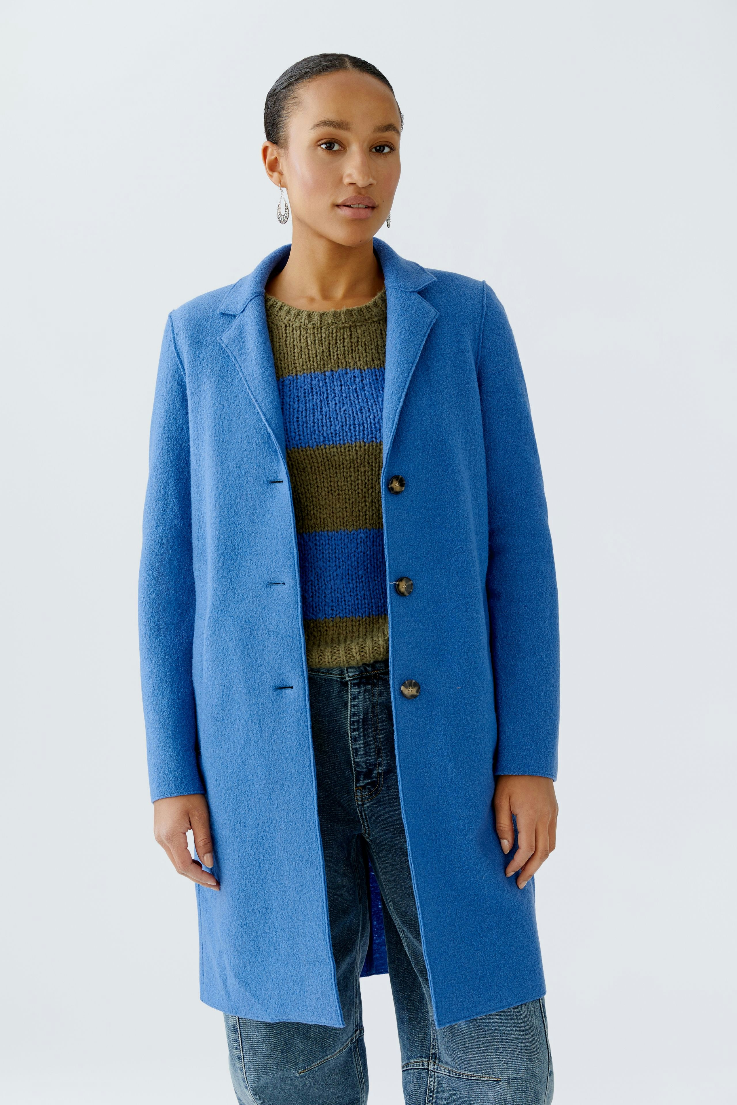 Wool coat: Woman in a blue wool coat over a striped pullover and relaxed jeans.