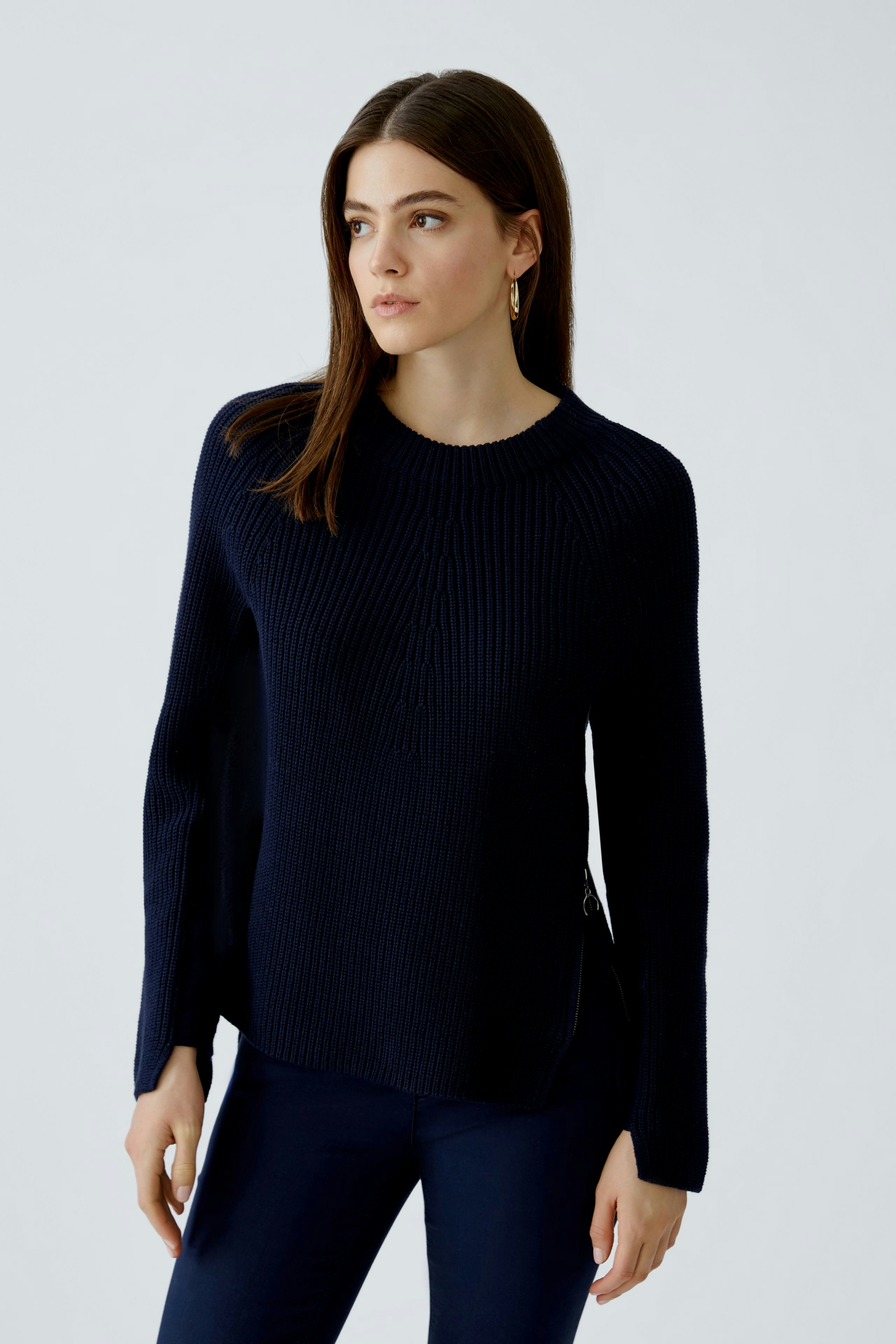 Modern women's pullover: A woman in a navy ribbed pullover with a relaxed fit and stylish design.