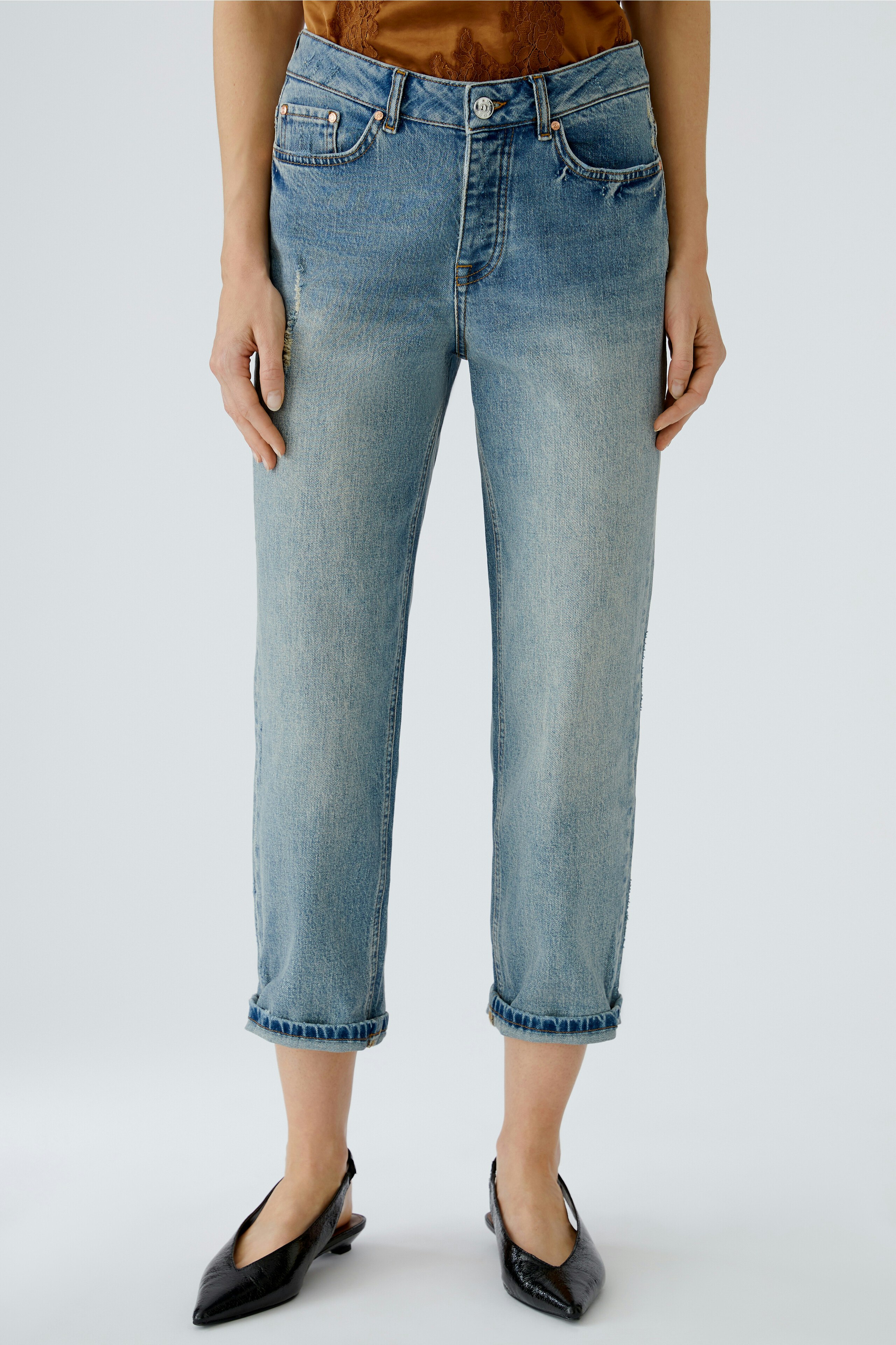Casual women's jeans: A woman in light blue rolled-up jeans, paired with stylish black shoes.
