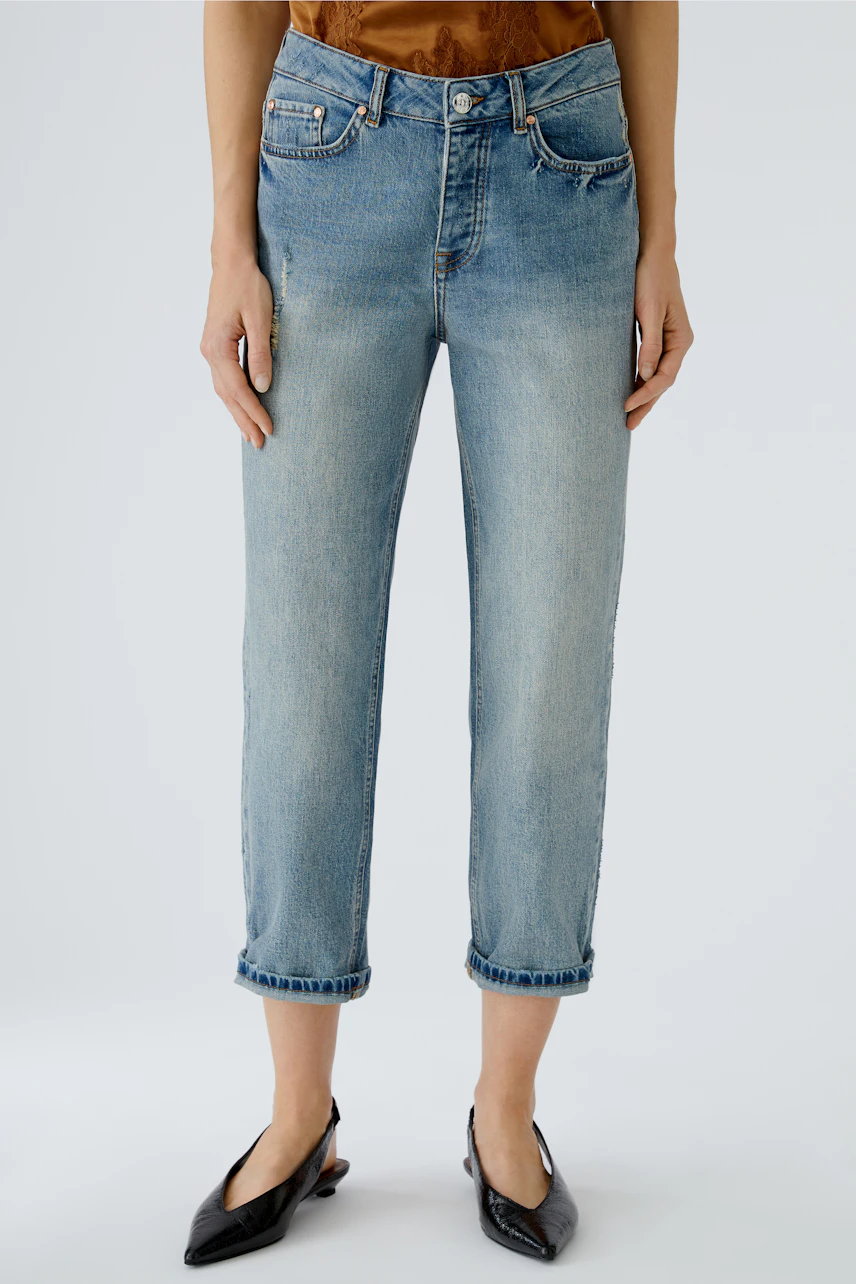 Casual women's jeans: A woman in light blue rolled-up jeans, paired with stylish black shoes.