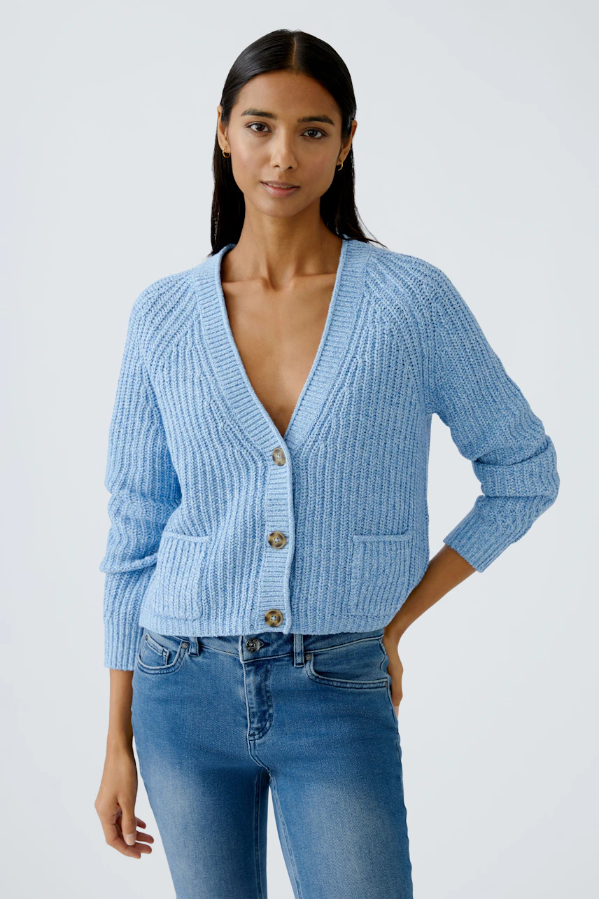 Stylish women's cardigan: A woman in a light blue cardigan with buttons and pockets, exuding casual elegance.