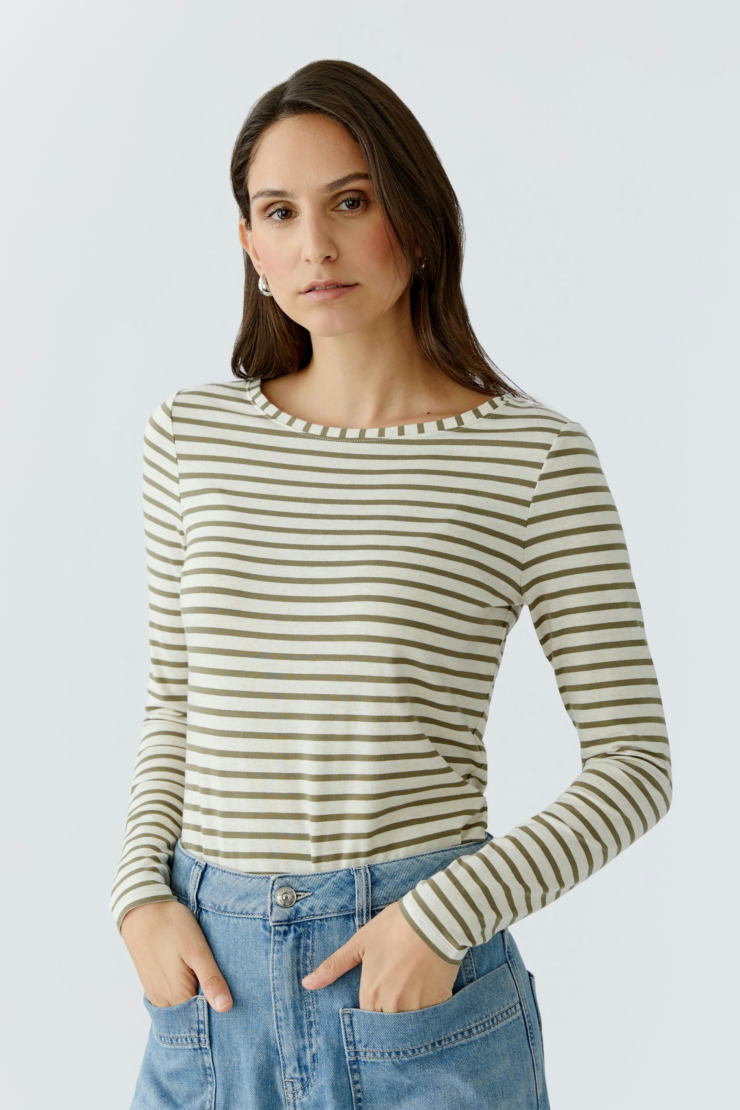 Casual long-sleeve shirt: Woman in a striped pullover with a relaxed fit, paired with denim.