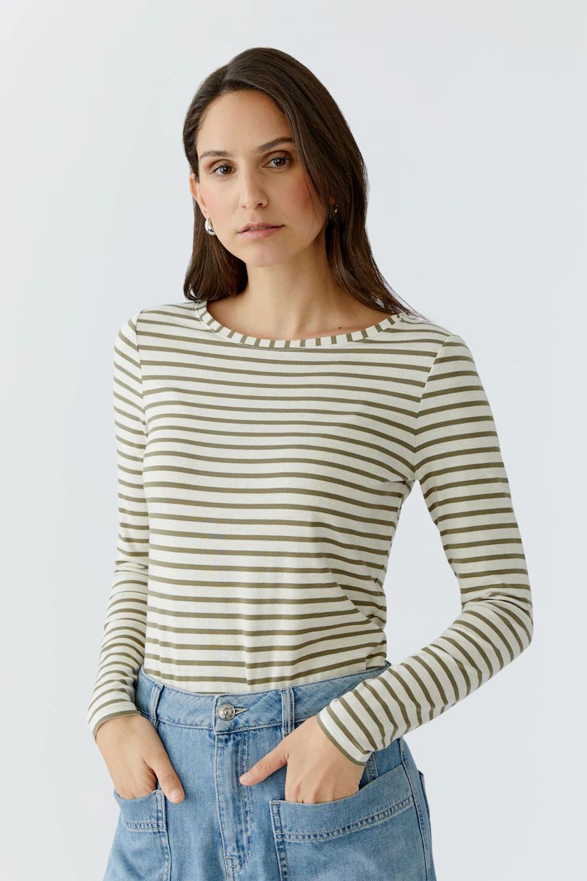 Casual long-sleeve shirt: Woman in a striped pullover with a relaxed fit, paired with denim.