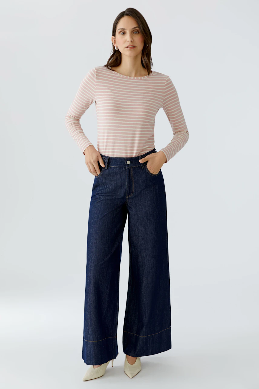 Casual long-sleeve shirt: Woman in a pink striped shirt paired with wide-leg jeans.