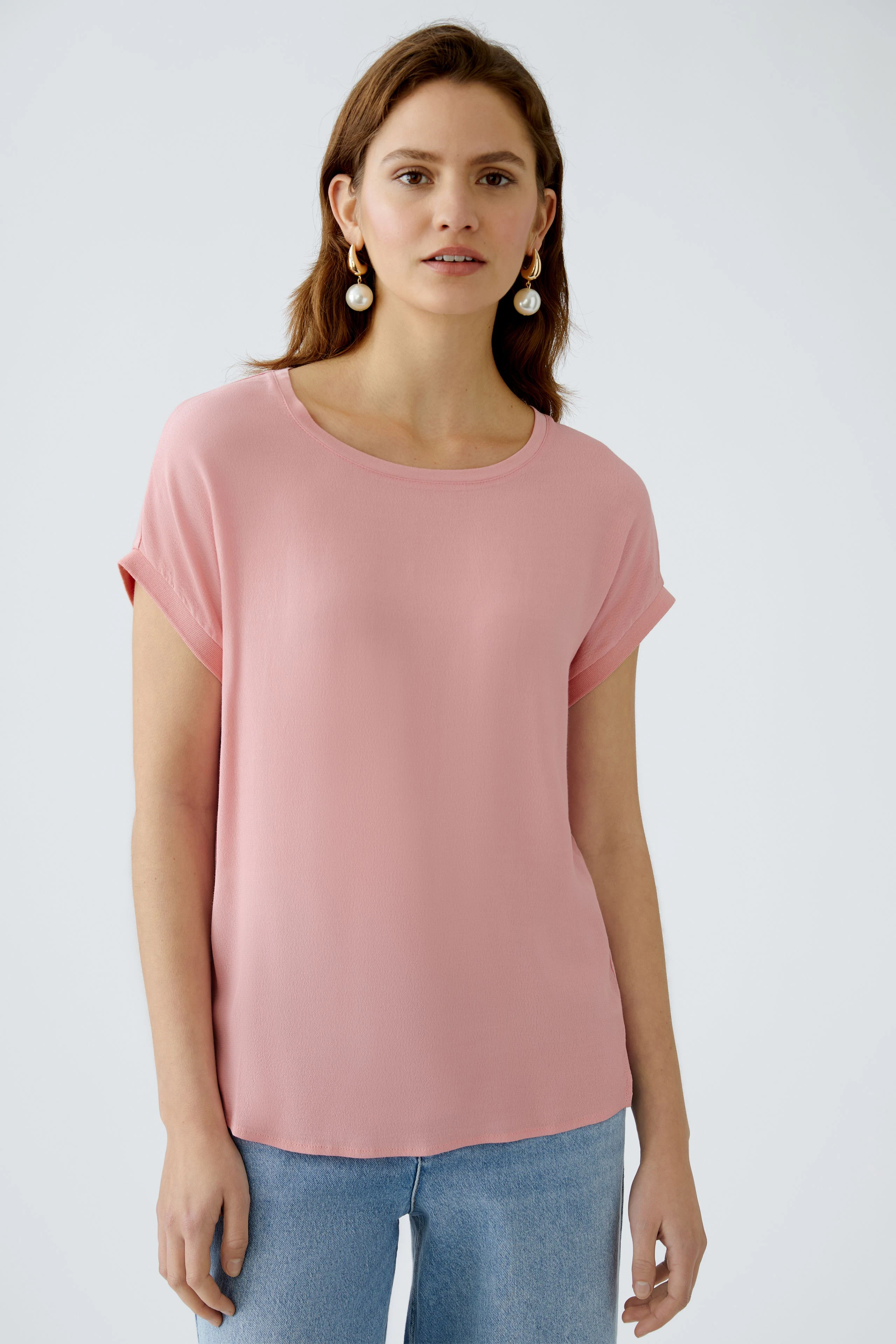 Stylish women's blouse shirt in soft pink, featuring a relaxed fit and rolled sleeves.