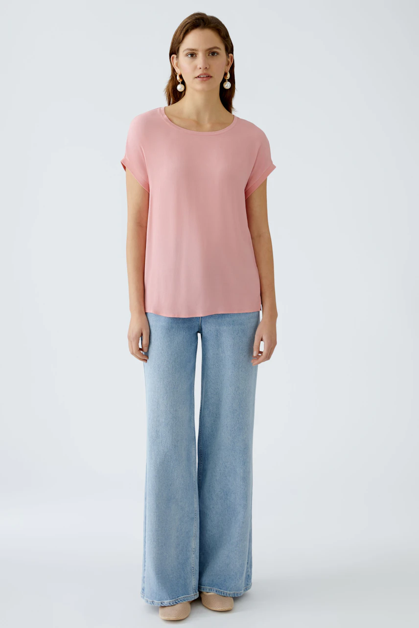 Stylish women's blouse shirt: A woman in a pink blouse paired with wide-leg jeans, exuding casual elegance.