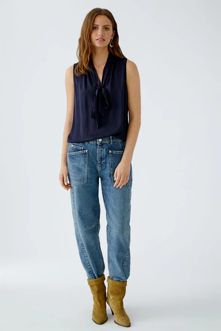 Sleeveless blouse: A woman in a navy top with a bow tie detail, perfect for casual outings.