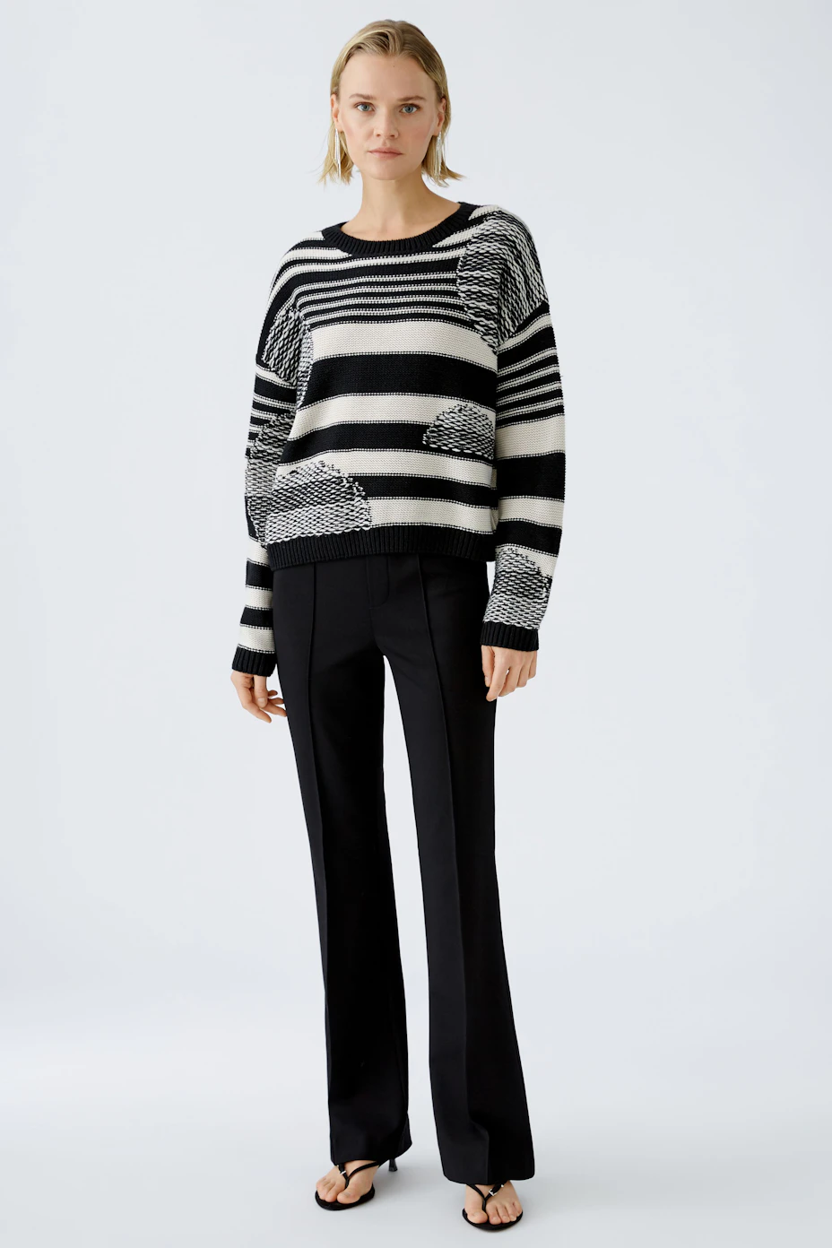 Stylish women's pullover: Black and white striped design with a relaxed fit.