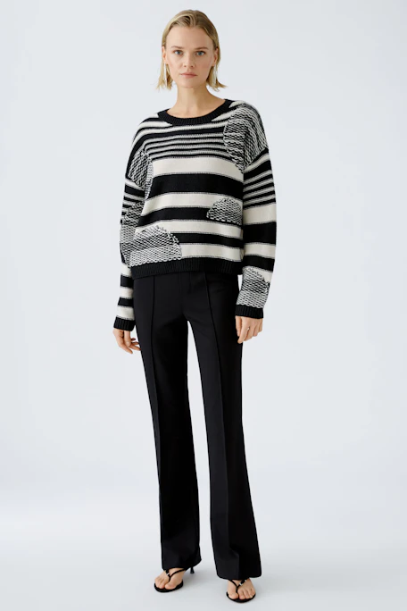 Damen-Pullover in Schwarz-Weiß mit gestreiftem Muster und lässigem Schnitt.