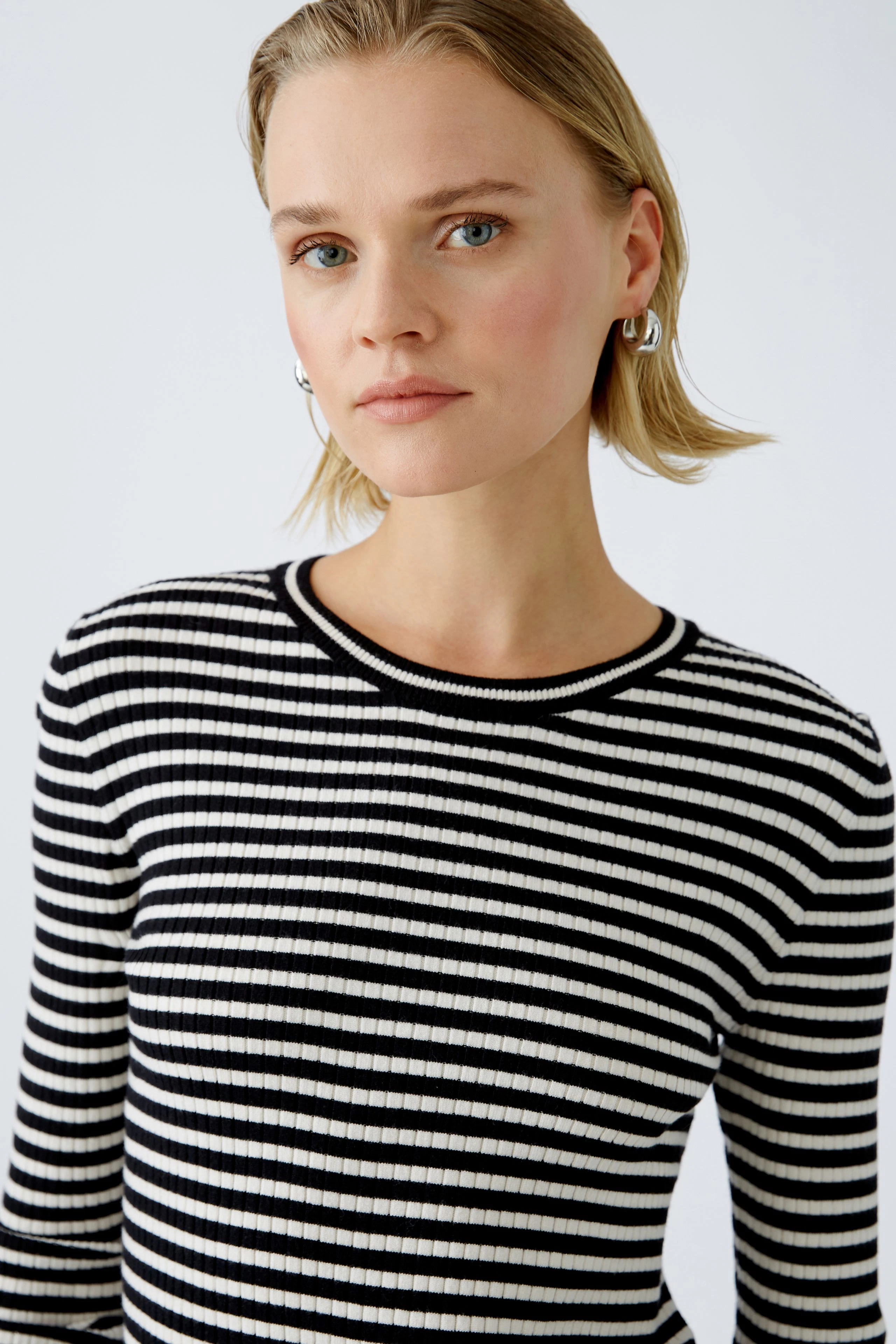 Damen-Pullover: Frau in gestreiftem Pullover mit Rundhalsausschnitt und lässigem Look.