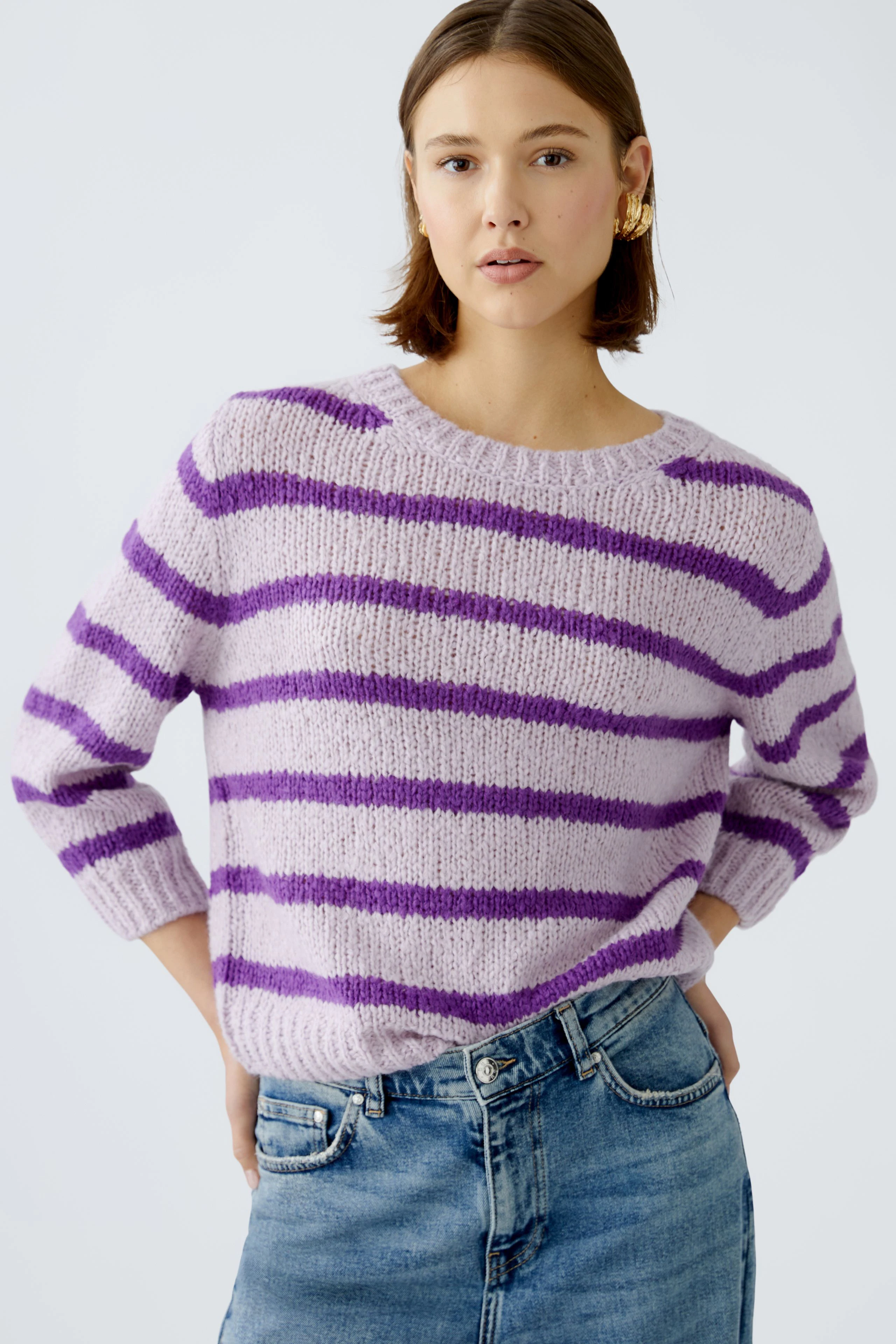 Modern women's pullover: A woman in a lilac striped pullover with relaxed fit and casual style.