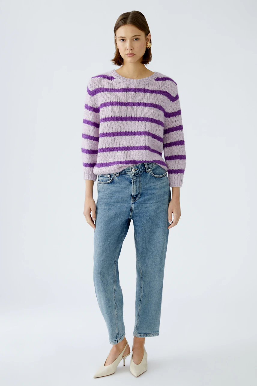 Damen-Pullover: Frau in lila-gestreiftem Pullover mit lässigen Jeans und eleganten Schuhen.