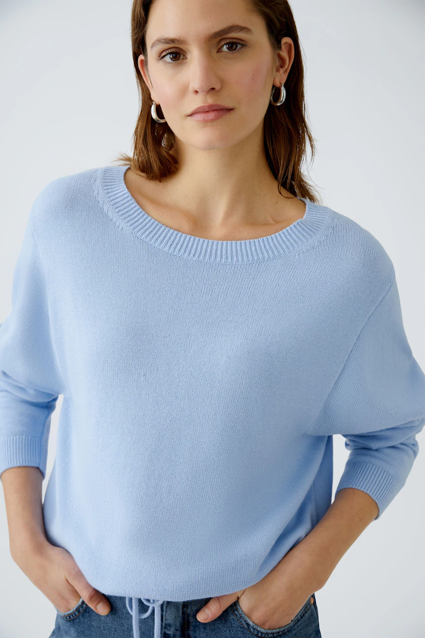Damen-Pullover: Junge Frau in hellblauem, lässigem Strickpullover mit Rundhalsausschnitt.