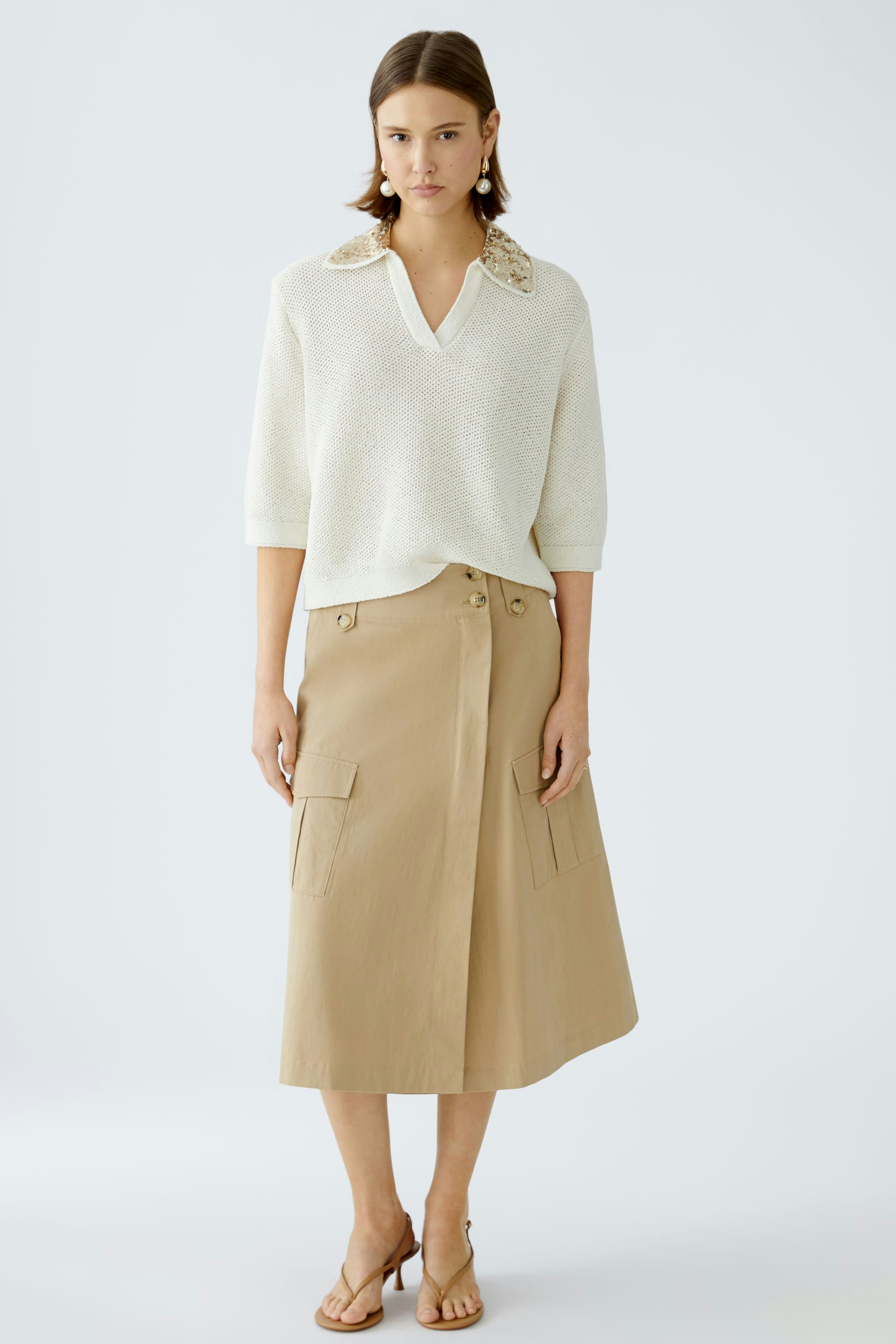 Stylish women's pullover with a unique collar, paired with a chic skirt for a modern look.