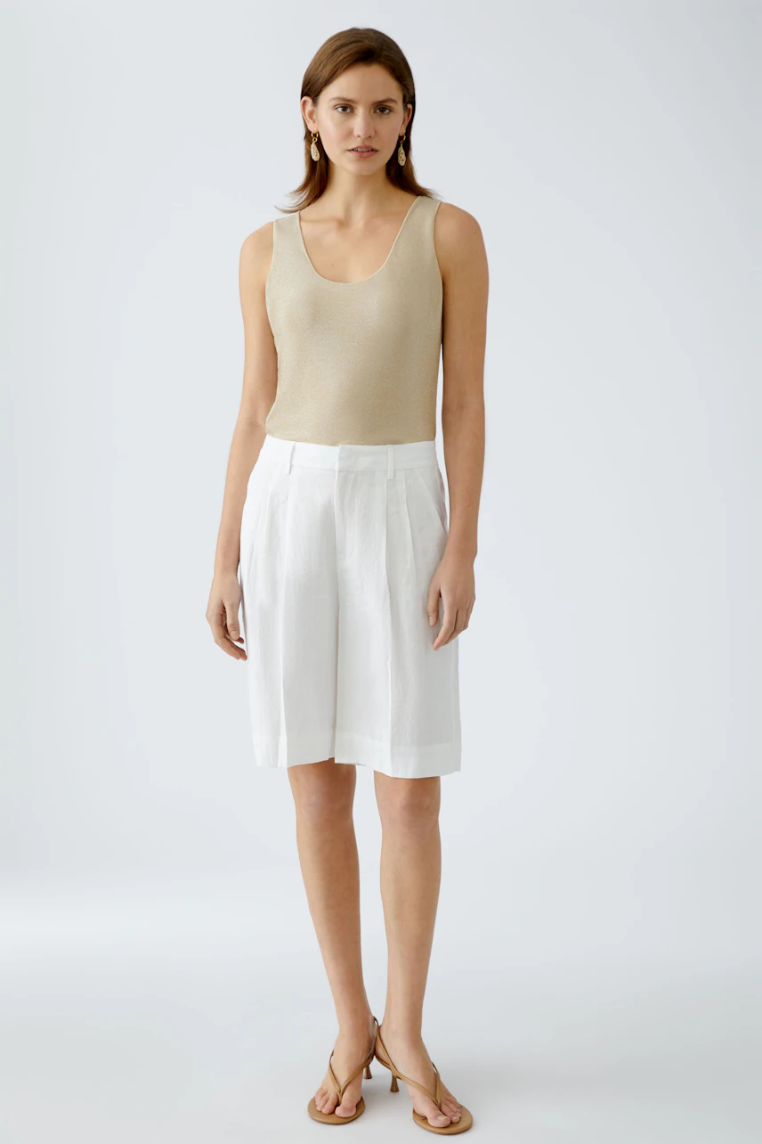 Beige Damen-Tank Top: Frau in schmalem, ärmellosem Oberteil mit elegantem Schnitt und lässiger Shorts.